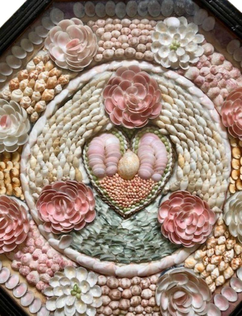 Antique Large Sailor's Valentine in Ebonized Case, circa 1920, a hand-crafted shell collage with hear and rosebuds pattern set in a large ebonized octagonal shadowbox, wired on the reverse for hanging. 

The valentine and case remain in very good