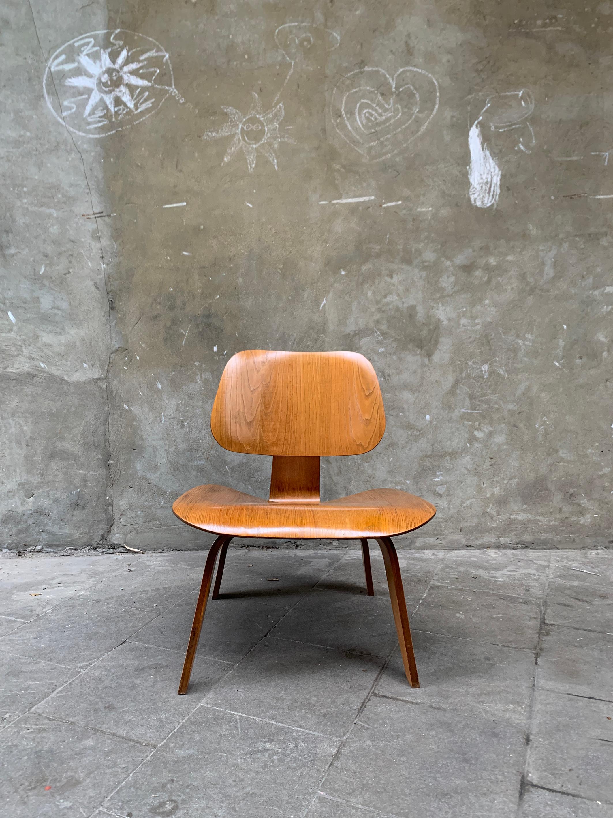 An early LCW (Lounge Chair Wood) in Calico Ash veneer. Chair sold by Herman Miller, but still produced by Evans Plywood probably in 1948. 

The 5-2-5 screw arrangement beneath has only be used by Evans Products. Herman Miller produces from 1949-1950