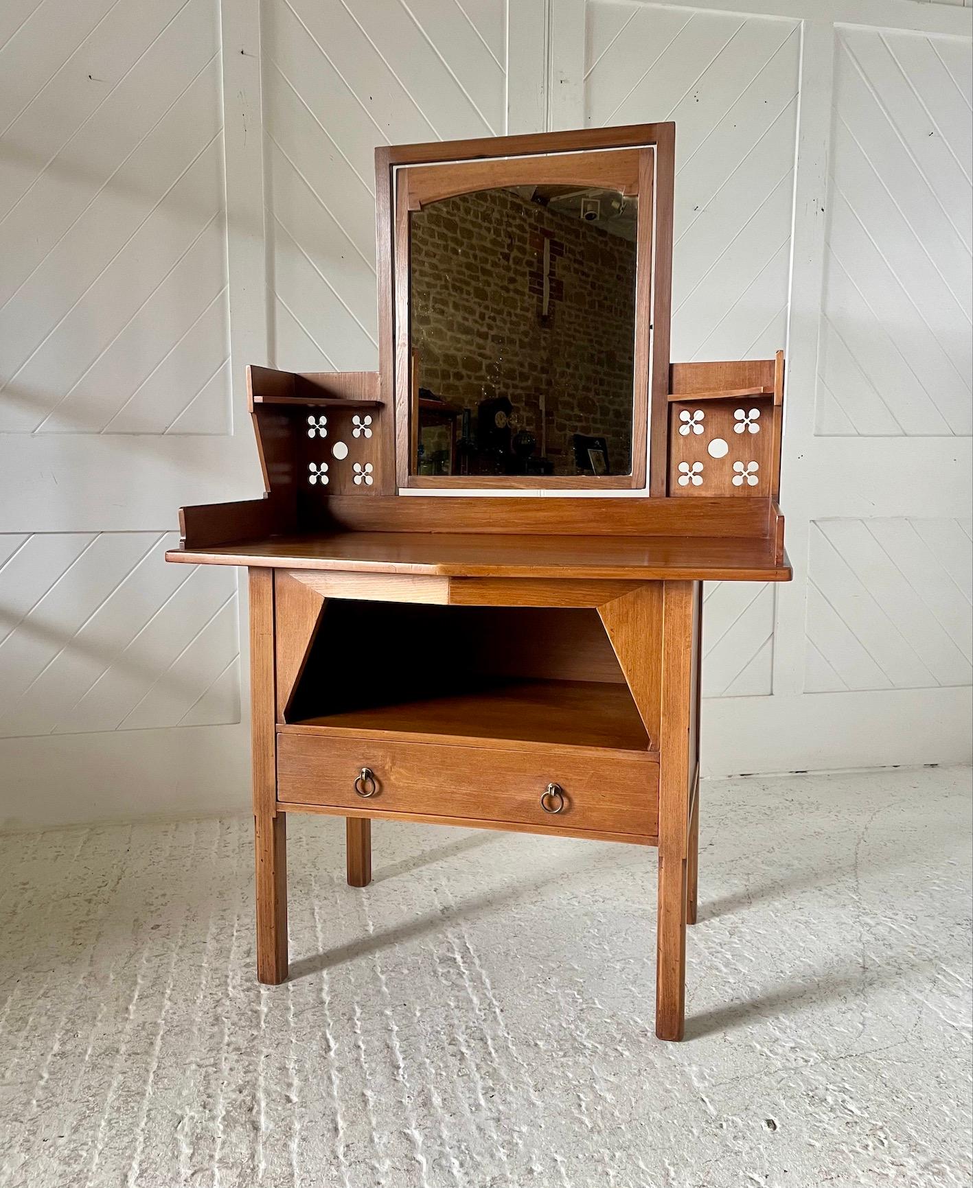 We have for offer a wonderful Arts & Crafts dressing table
It is in Sycamore
There is a central tilting mirror with pierced decoration to either side
A pull out bottom drawer with brass ring handles
Enamel early Liberty & Co label to the reverse
In