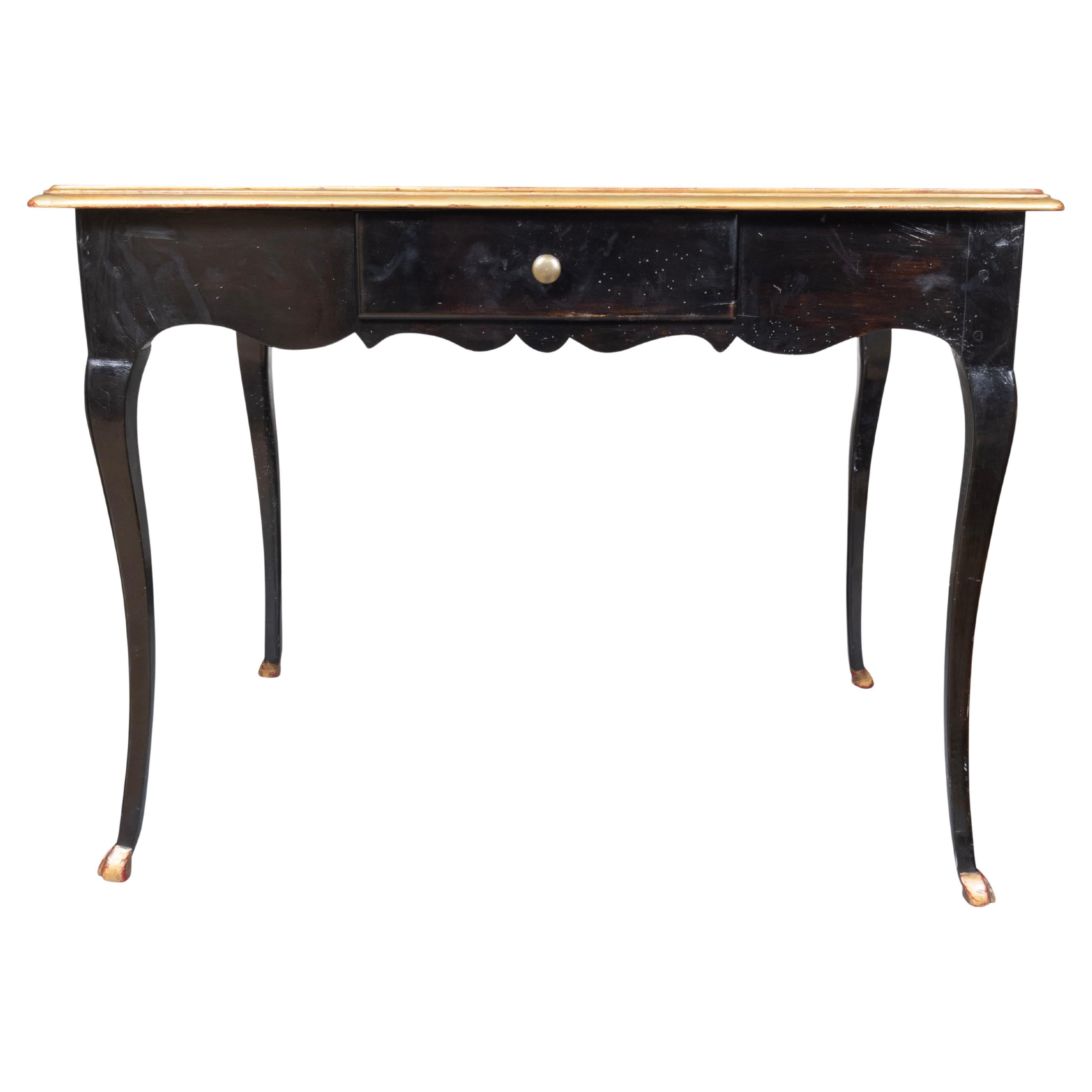 Rectangular top with inset reddish brown leather and gilded outer edge. The frieze with single drawer. Raised on cabriole legs and hoof feet.