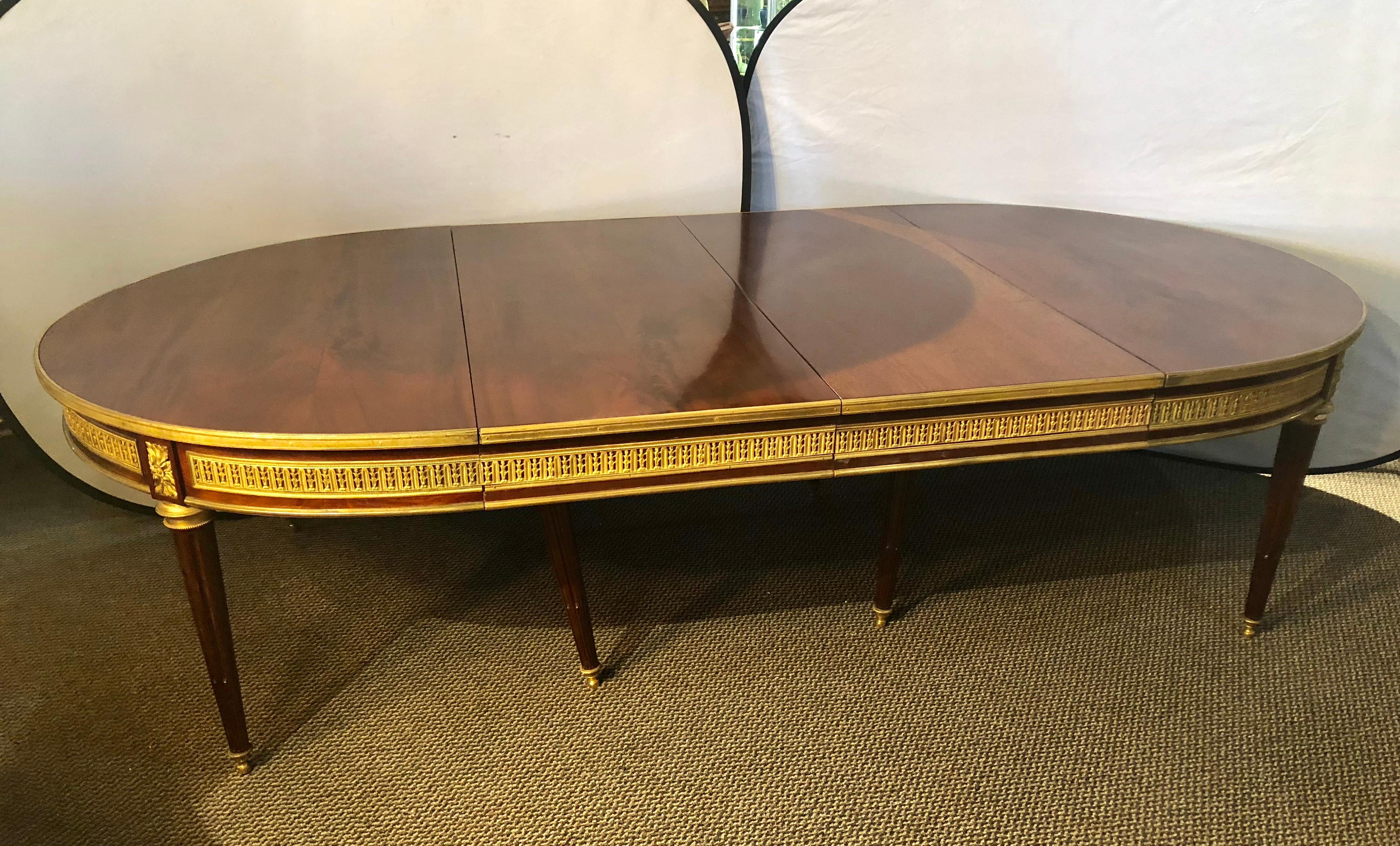 The finest late19th-early 20th century French dining table on the market. An Early Maison Jansen bronze mounted crotch mahogany dining table. Simply the most spectacular, almost circular, dining table by this highly sought after designer having two