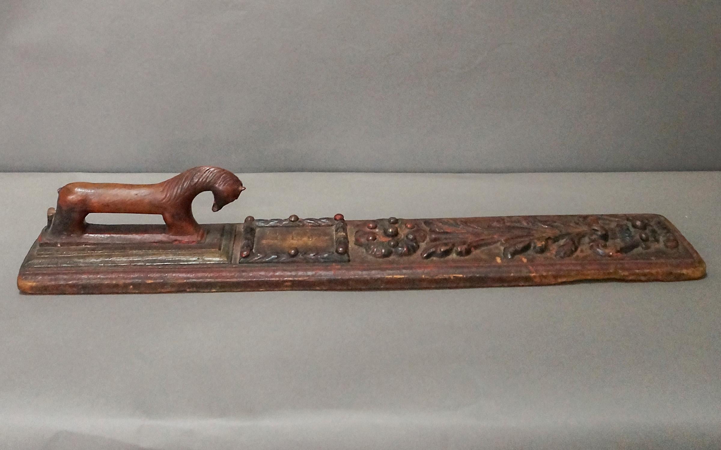 Masterfully carved mangle board, Sweden circa 1740, having a horse-shaped handle with arching neck and refined head. The board itself has a rose and vase in bold relief and a raised frame around the initials of the intended bride. Remnants of the