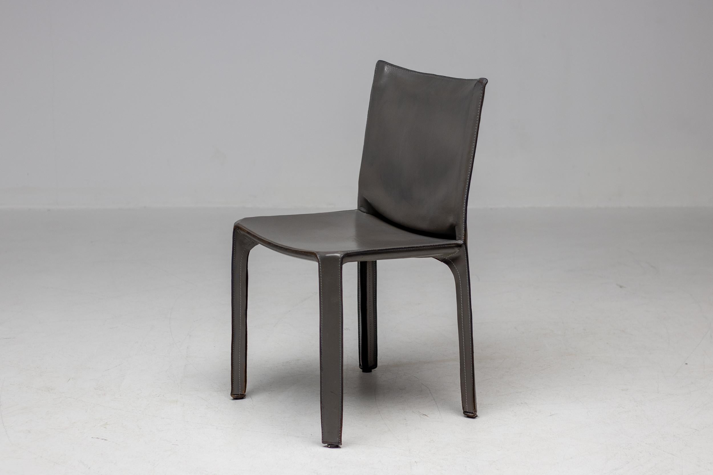 Iconic elephant hide grey leather CAB dining chairs designed by Mario Bellini in 1977 for Cassina.
Very early examples with thin flat seat bottom instead of the later thick bottom in nice vintage condition. 

The Cab chair provides remarkable