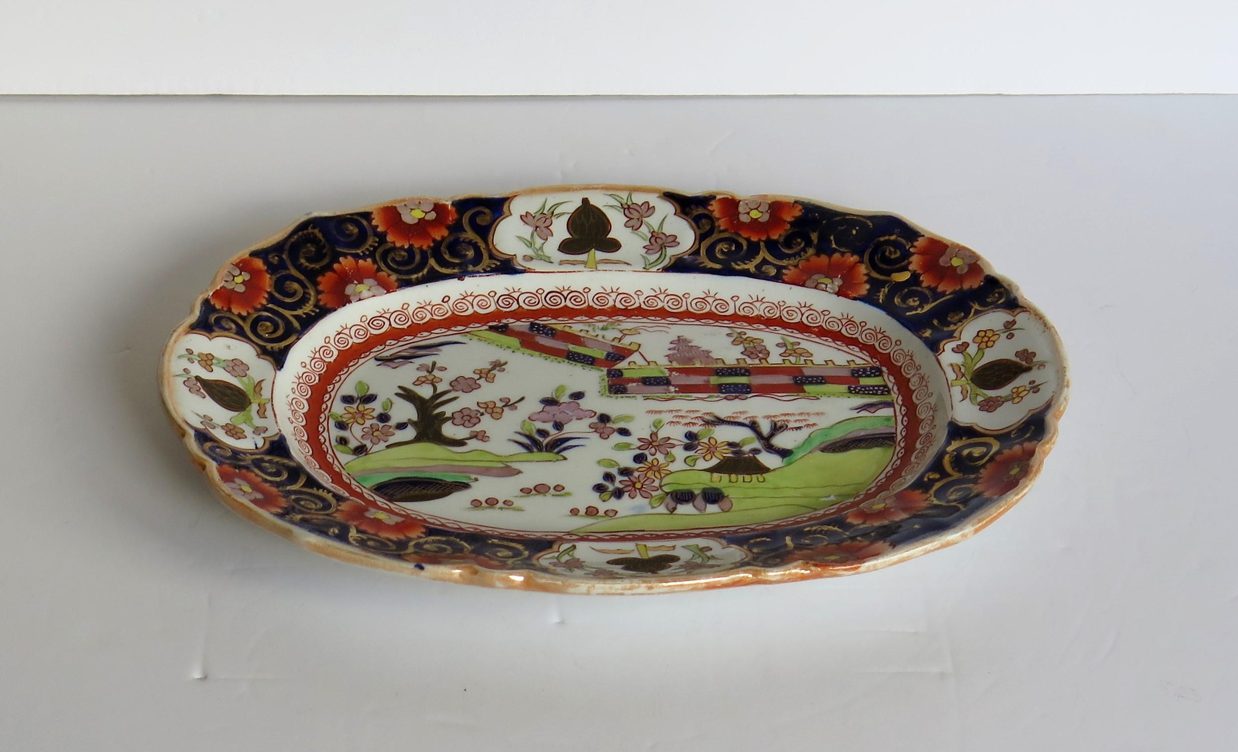 This is an early platter or oval plate, hand painted in the colored wall pattern by Mason's Ironstone, Lane Delph, England, dating to circa 1825.

The piece is well potted in an oval shape with a wavy rim.

This very decorative pattern is hand