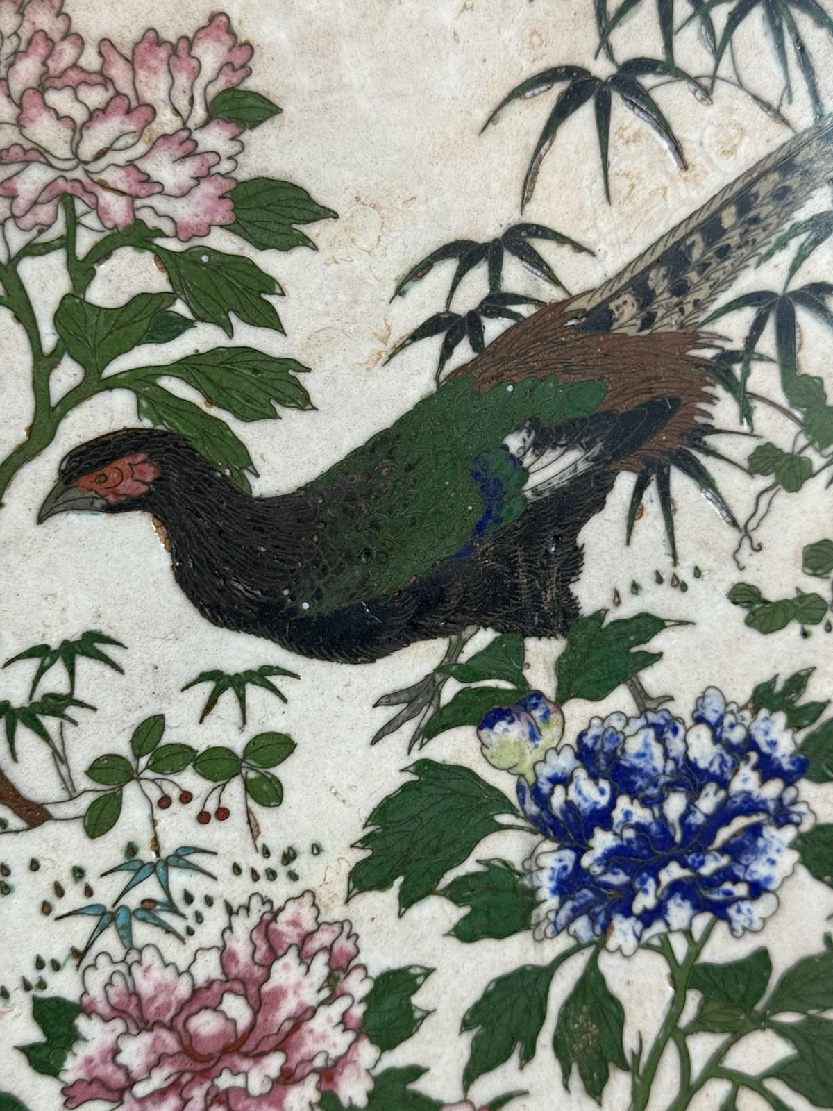 Un importante caricatore in smalto cloisonne giapponese dei primi anni Meiji su un raro fondo bianco, del diametro di 17,5 pollici. Il medaglione centrale mostra un fagiano finemente dettagliato tra bambù e fiori lussureggianti, seguito da farfalle