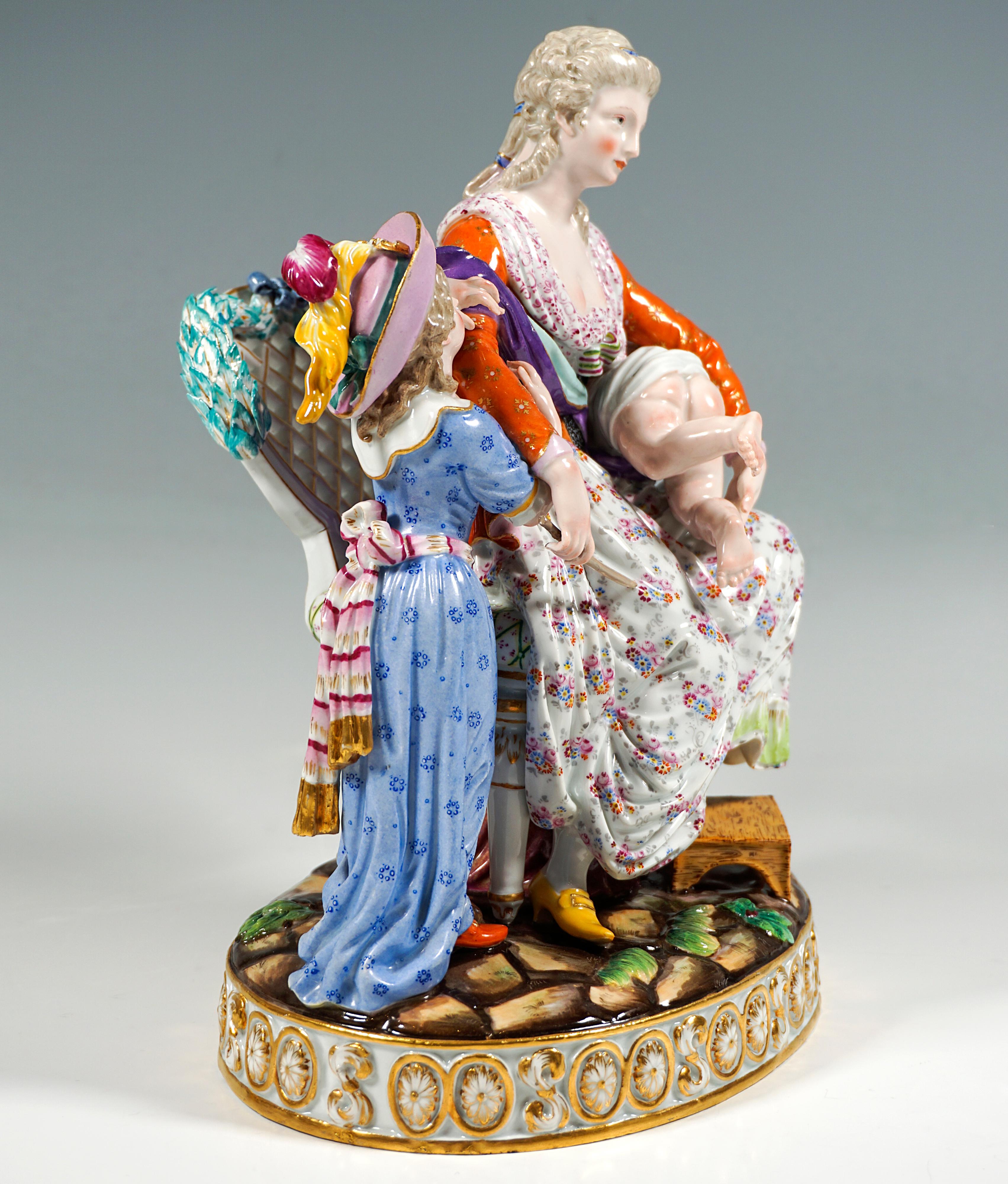 Exceptional Meissen porcelain genre group:
Young mother seated on a magnificent Louis XVI-style armchair, her left foot set down on a low stool, a boy lying on his stomach on her left thigh, his white shirt slipped up to reveal his bare buttocks,