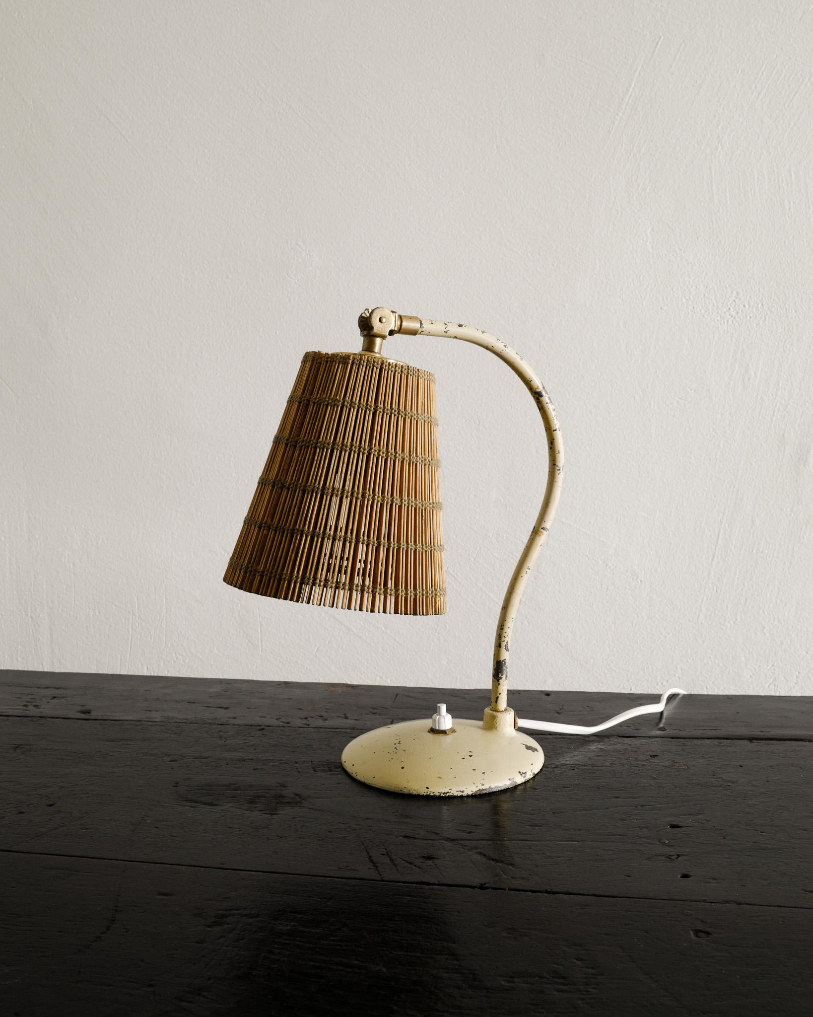 Very rare and early mid century desk / bed table lamp by Paavo Tynell in lacquered metal, brass and a pine straw shade. Produced by Taito Finland, 1930s. In good vintage condition and so is the shade. 

Dimensions: H: 29 cm / 11.40