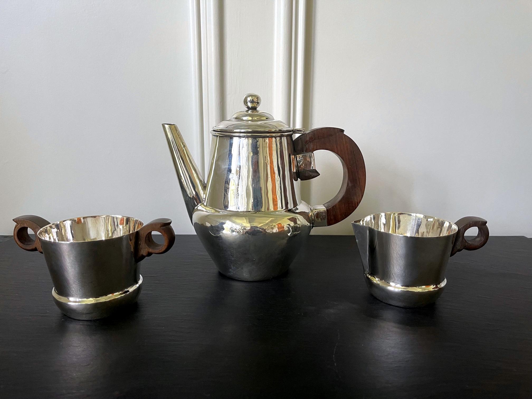 An early set of sterling silver coffee or tea set comprising a coffee or tea pot, a cream jug and an open sugar bowl. Designed and made by William Spratling in Taxco, Mexico and dated to his first design period 1944-1946 indicated by the various