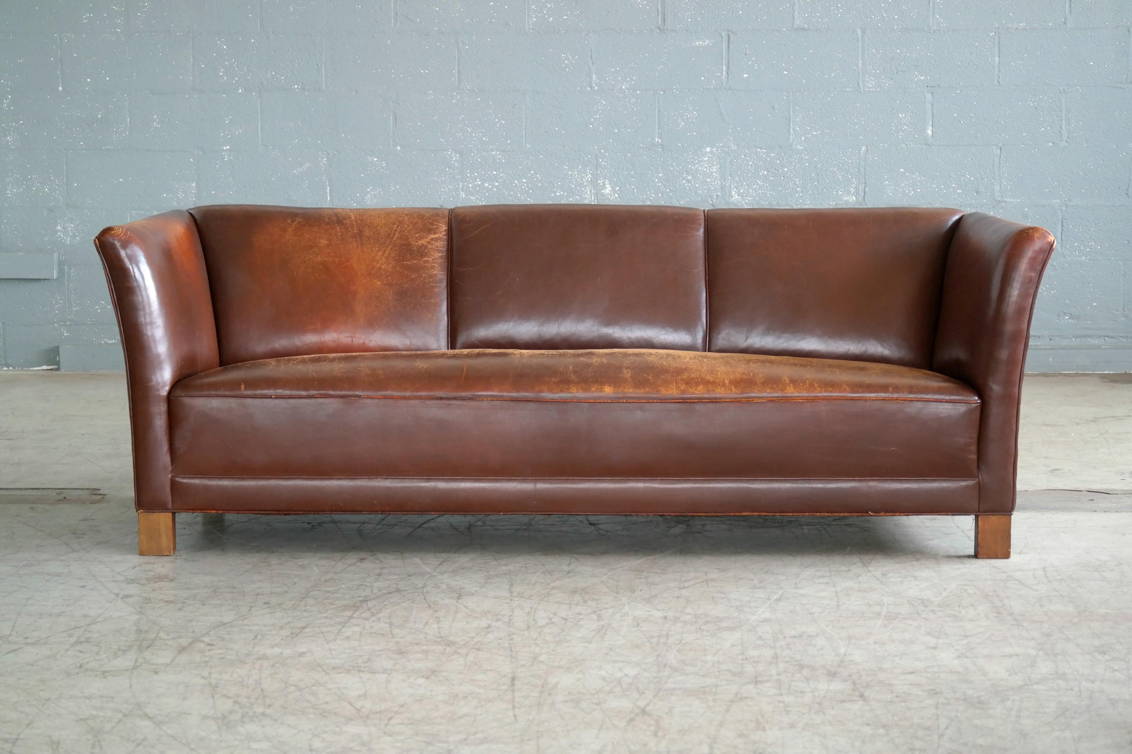 Rare Danish club sofa in chestnut brown leather produced in Denmark likely, circa 1940 by Fritz Hansen of Denmark. Legs made from solid beech. Comfortable and super solid with nice and supportive springloaded seat in overall very good condition