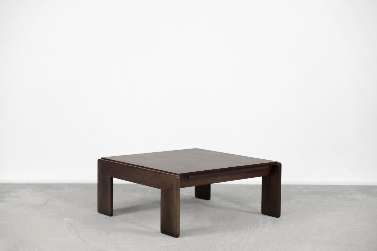 This low coffee table was designed by the architectural duo Tobia and Afra Scarpa in 1962 and manufactured by the Italian manufacture Gavina. It is an early production table from the Bastiano series. It is made of teak wood and finished in a dark