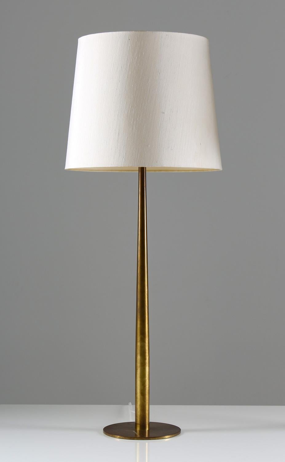 Pair of rare oversized table lamps model B86 by Hans-Agne Jakobsson. 
The design of these lamps are as simple as they are beautiful. A slim bottom plate holding a brass stem.
The feet differ slightly in size as they were produced in different