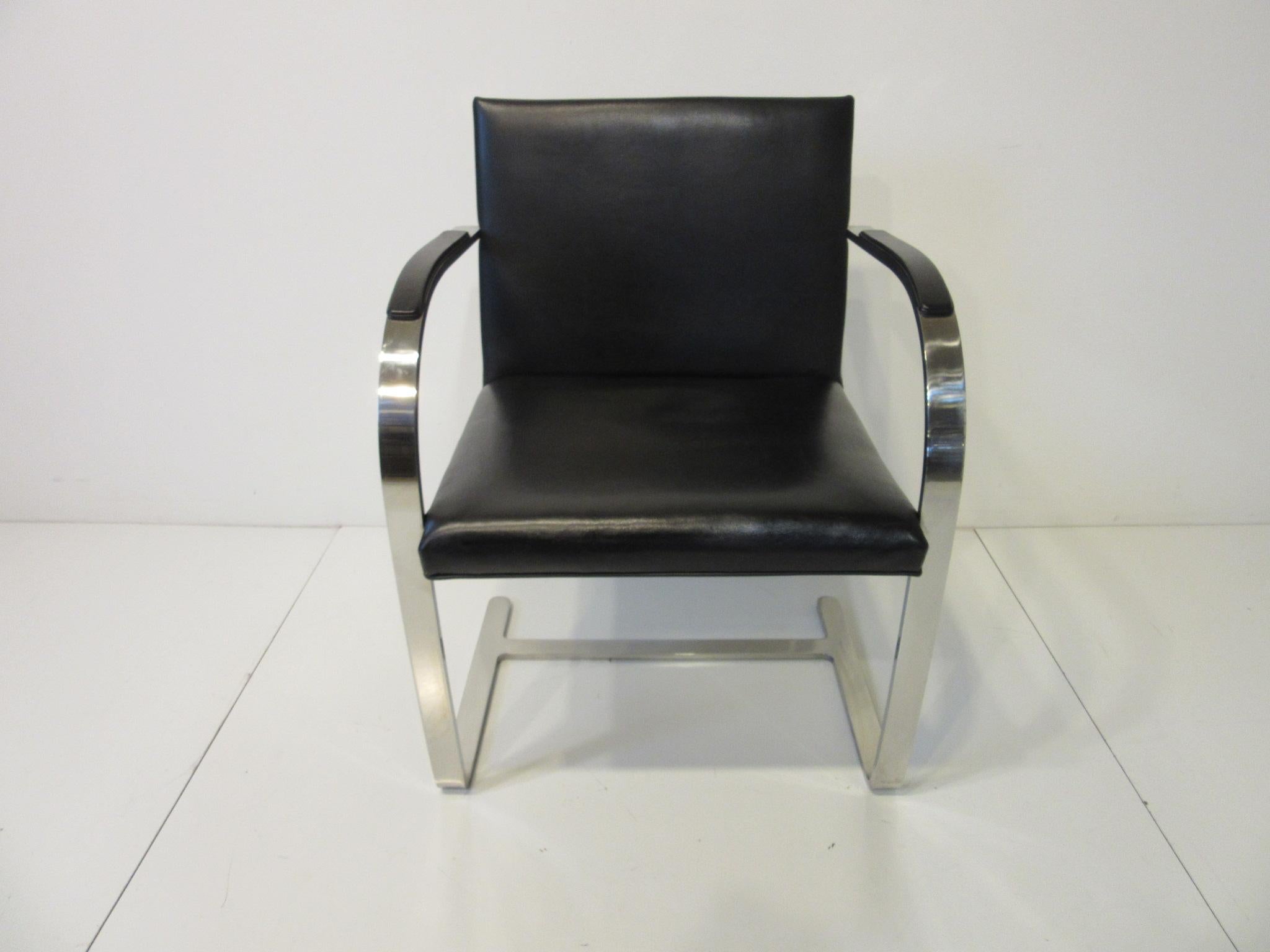 A set of six Brno flat bar armchairs with armpads for dining or conference use in Kenya black spinneybeck leather with bar stock stainless steel frames which are hand ground and have a hand buffed finish from the factory. Designed in the 1930s by