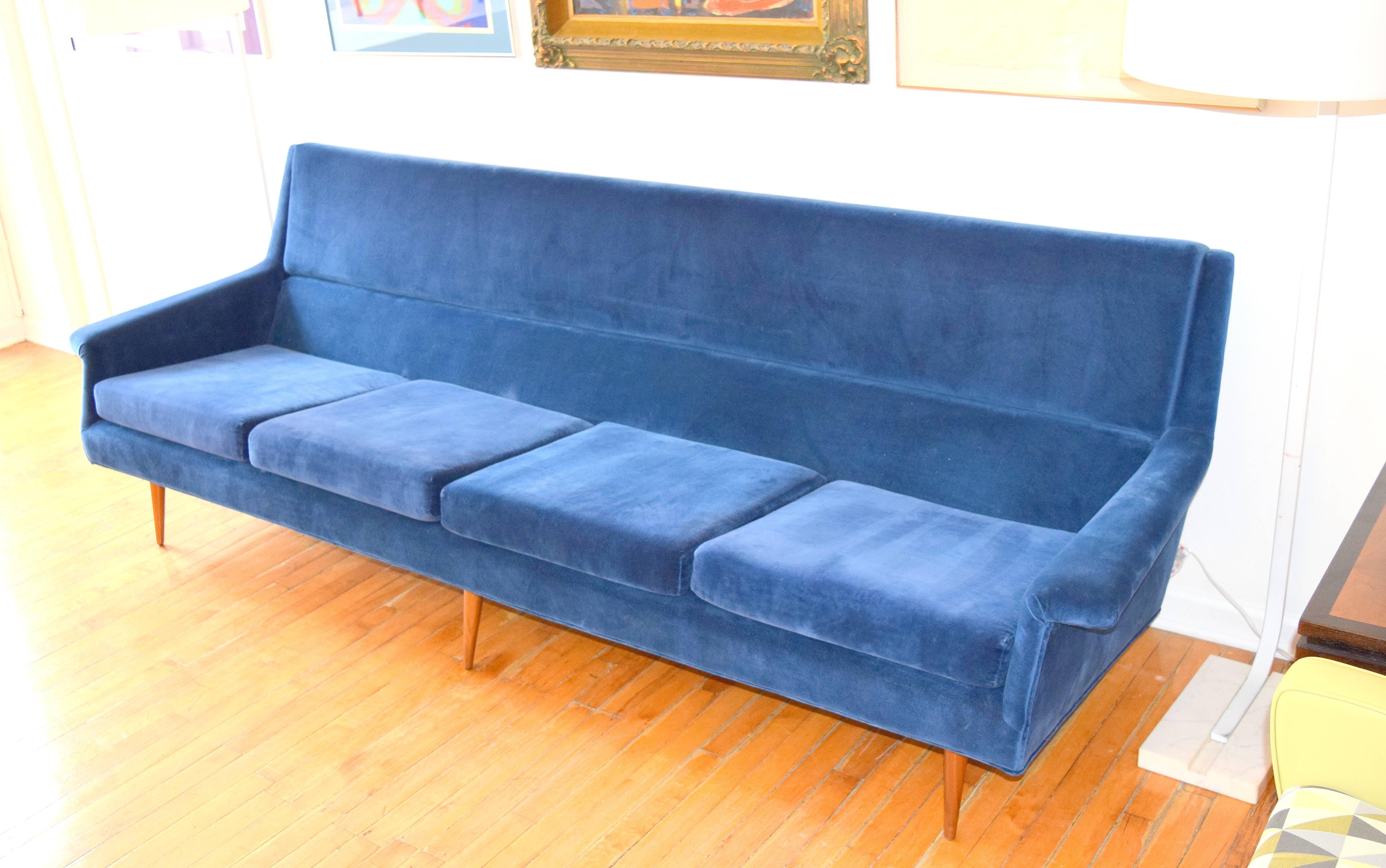 Striking angular sofa by Milo Baughman for Thayer Coggin. Wing like angular forms with tapered conical dowel legs, previously reupholstered in a royal blue velvet fabric. Long and sleek proportions with generous seating area yet extremely