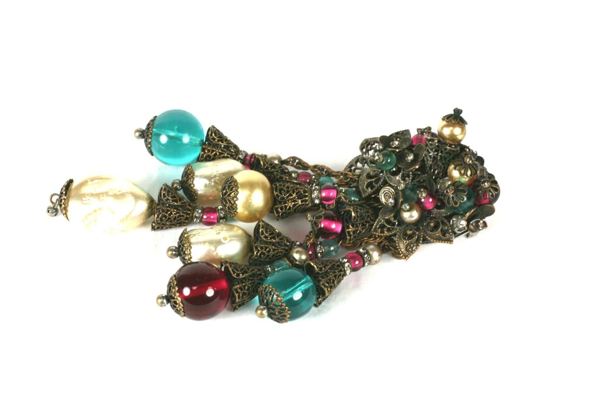 Early and large Miriam Haskell Pendant Brooch with faux pearls and ruby and blue pate de verre glass beads. 
Central motif has elaborately wired bead and floral filigree work in a patinaed bronze finish accented by pave crystals throughout.
Unsigned