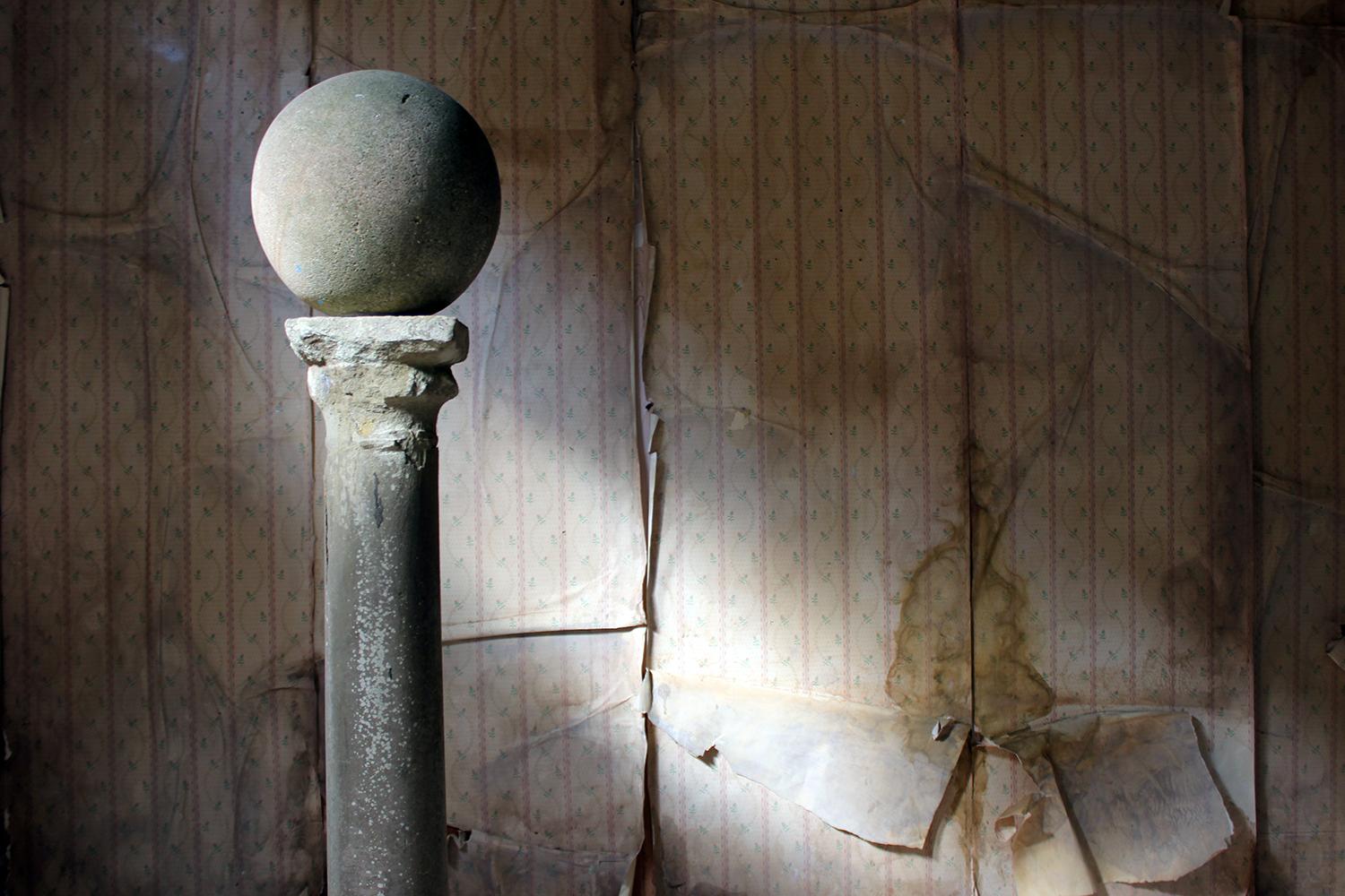 The limestone plinth column, of monastic origins, beautifully weathered with age, on a 20th century octagonal composition stone base and sphere top, surviving principally from the late medieval period.

The plinth has sub-millimetre flaking to the