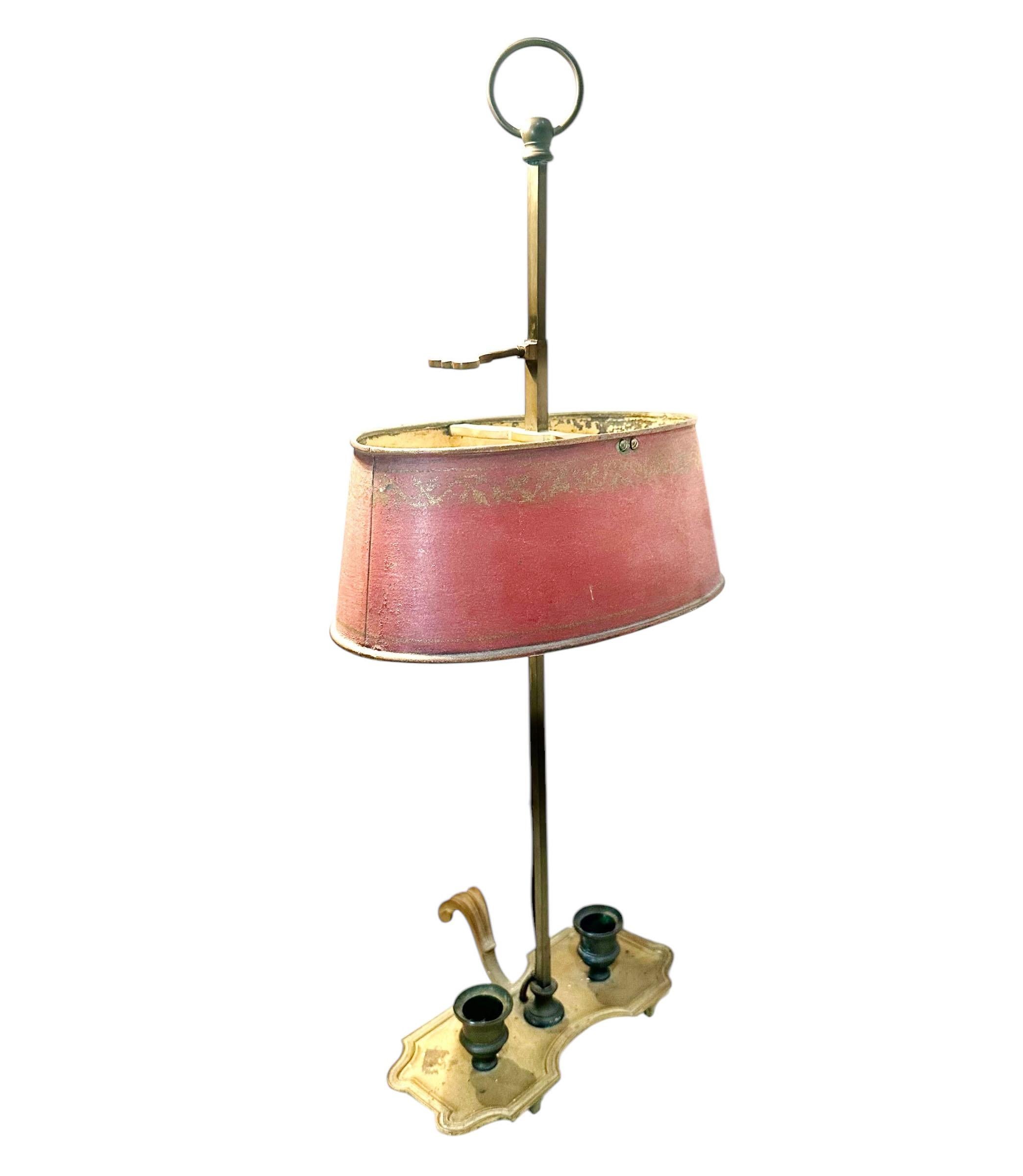 Una lámpara Bouillotte de bronce de principios de Napoleón III o más antigua. El tolete tiene el interior amarillo y el exterior rojo y el diseño dorado. Las dos velas electrificadas. 