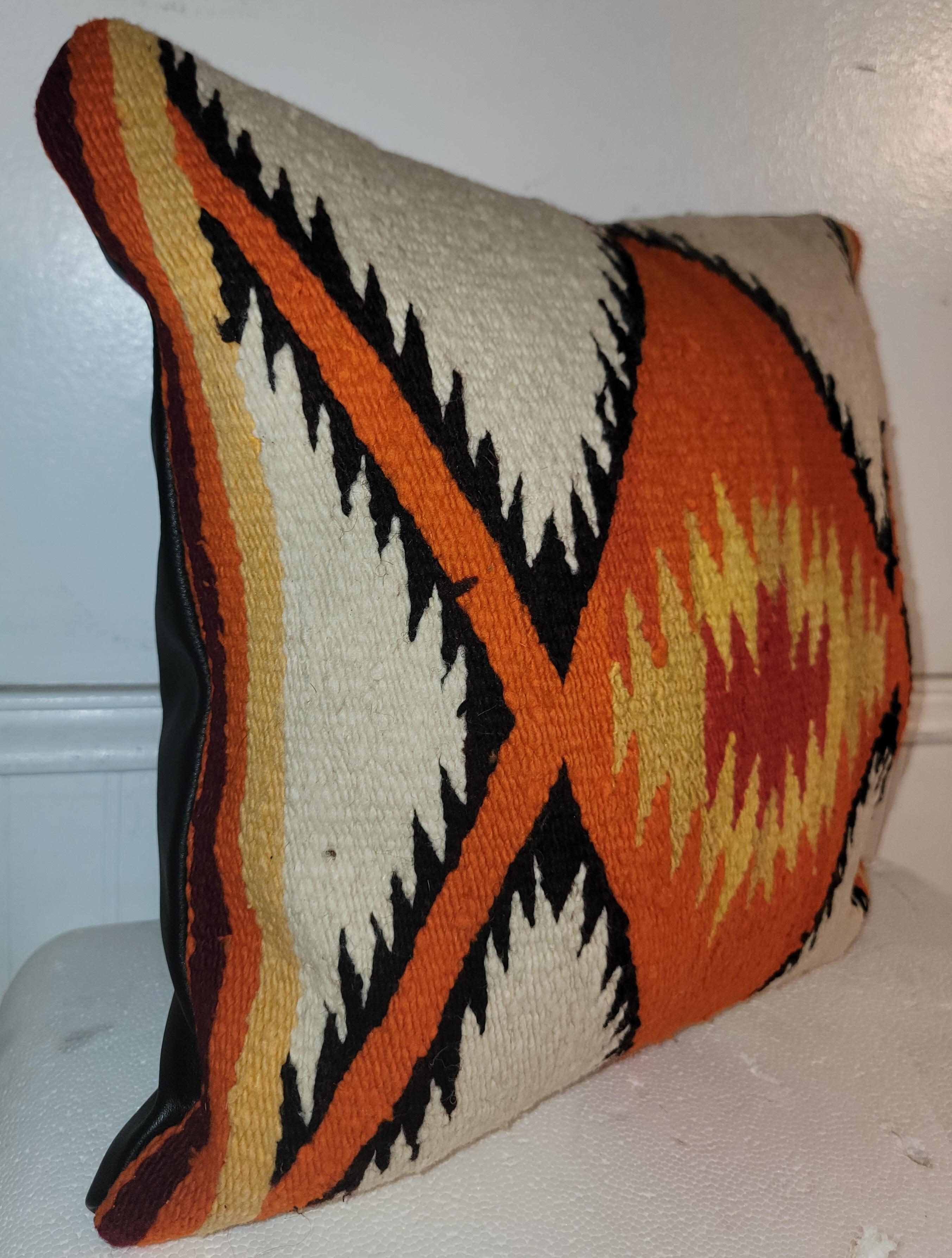 Early Navajo Indian weaving -eye dazzler in early burnt orange & black.The backing is in black leather.Down & feather fill.