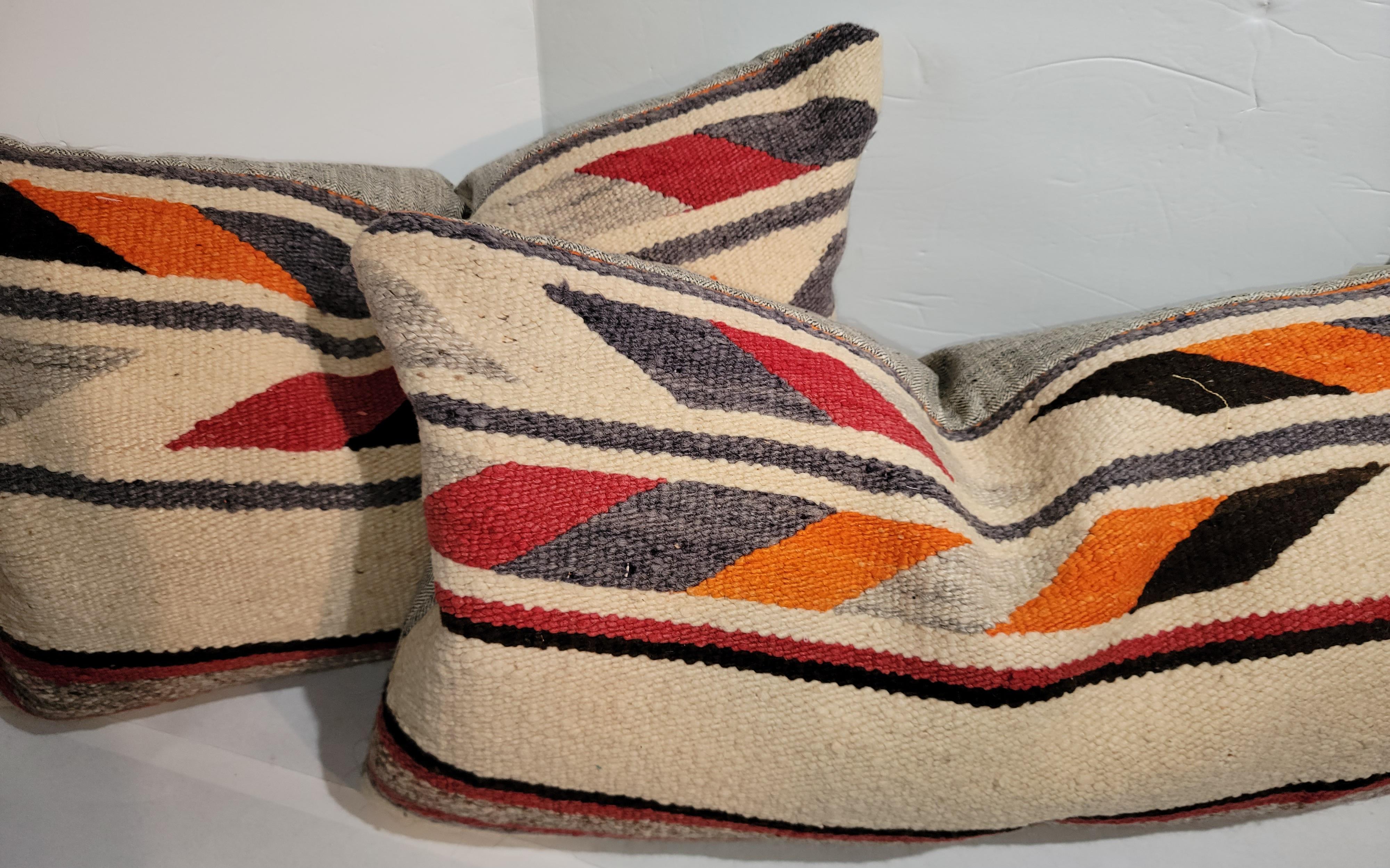These hand woven Navajo Indian weaving bolster pillows in the Navajo chevron style and linen backings. The inserts are down & feather fill.