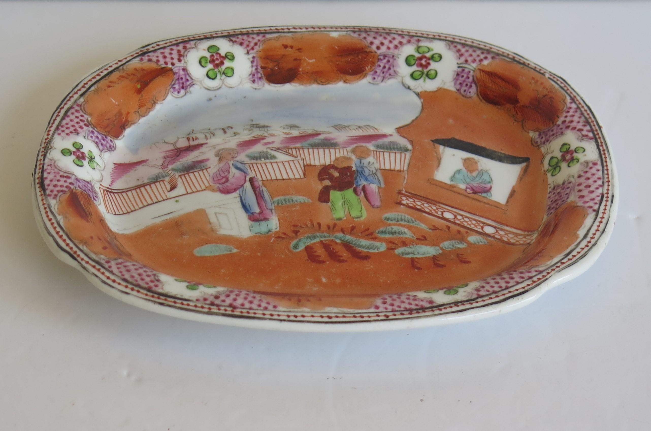 Dies ist eine harte Paste Porzellan Dish oder kleine Platte von New Hall aus sehr frühen 19. Jahrhundert, um 1800.

Diese Schale oder Platte ist auf einem niedrigen Fuß gut getopft. 

Die Dekoration ist handgemalt in kräftiger Emaille in einem