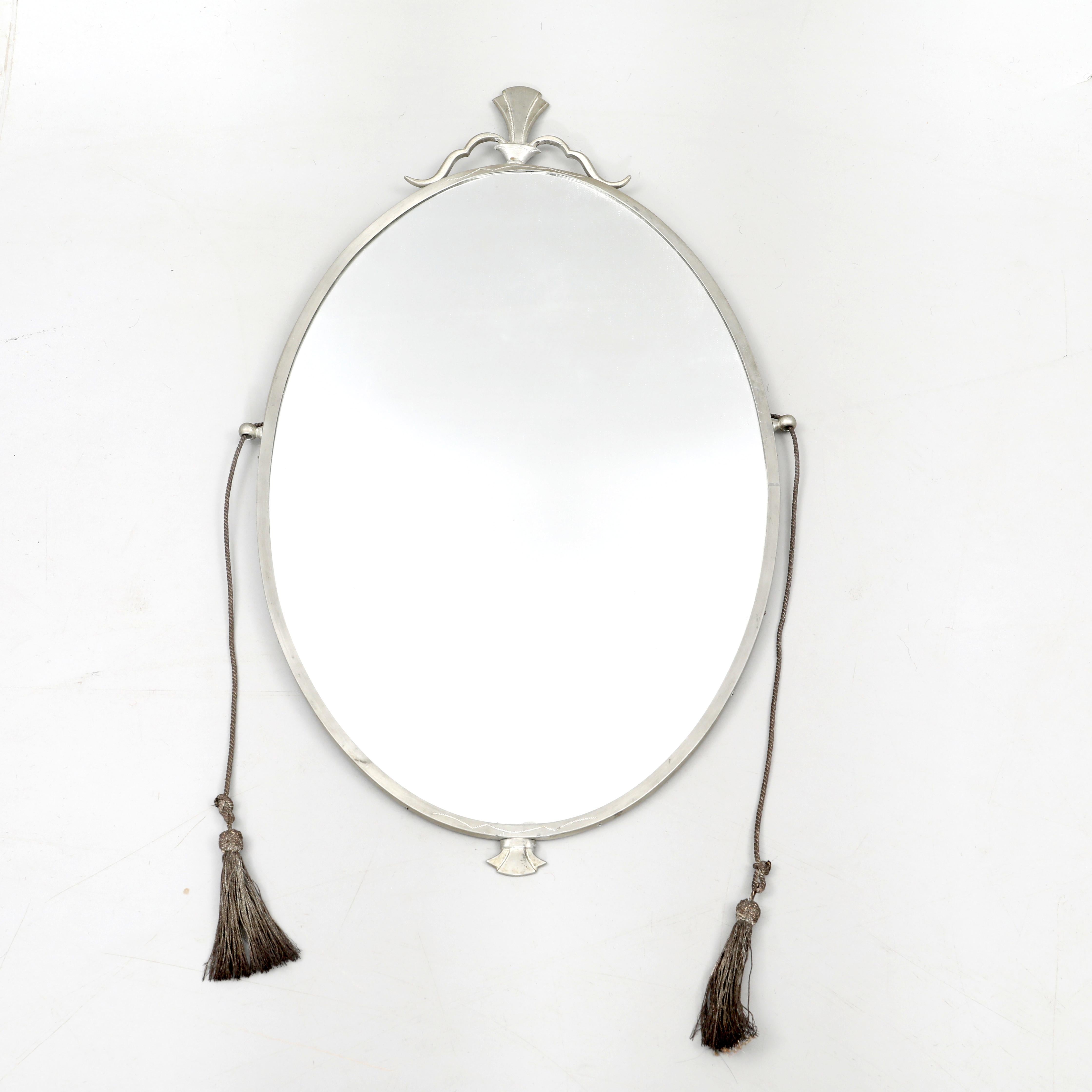 Nils Fougstedt - Scandinavian morden.

A beautiful oval mirror i pewter by Nils Fougstedt, Svenskt Tenn, Sweden 1930s. 

The mirror has a fine decoration and detailing and metal tassels. It is a very early mirror, hence there are signs of use