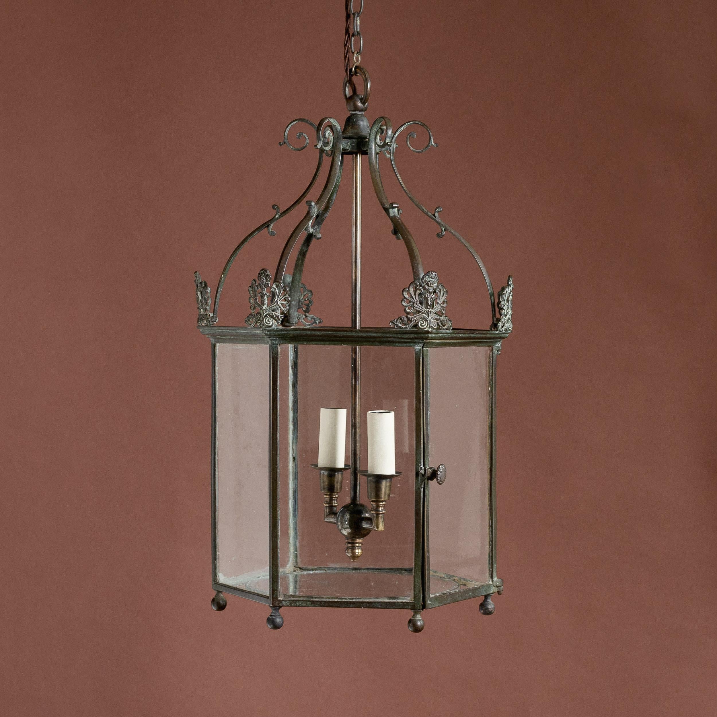 An early nineteenth century style hall lantern, mid-twentieth century, richly patinated brass frame with twin-light chandelier, re-wired and PAT tested to UK specifications.