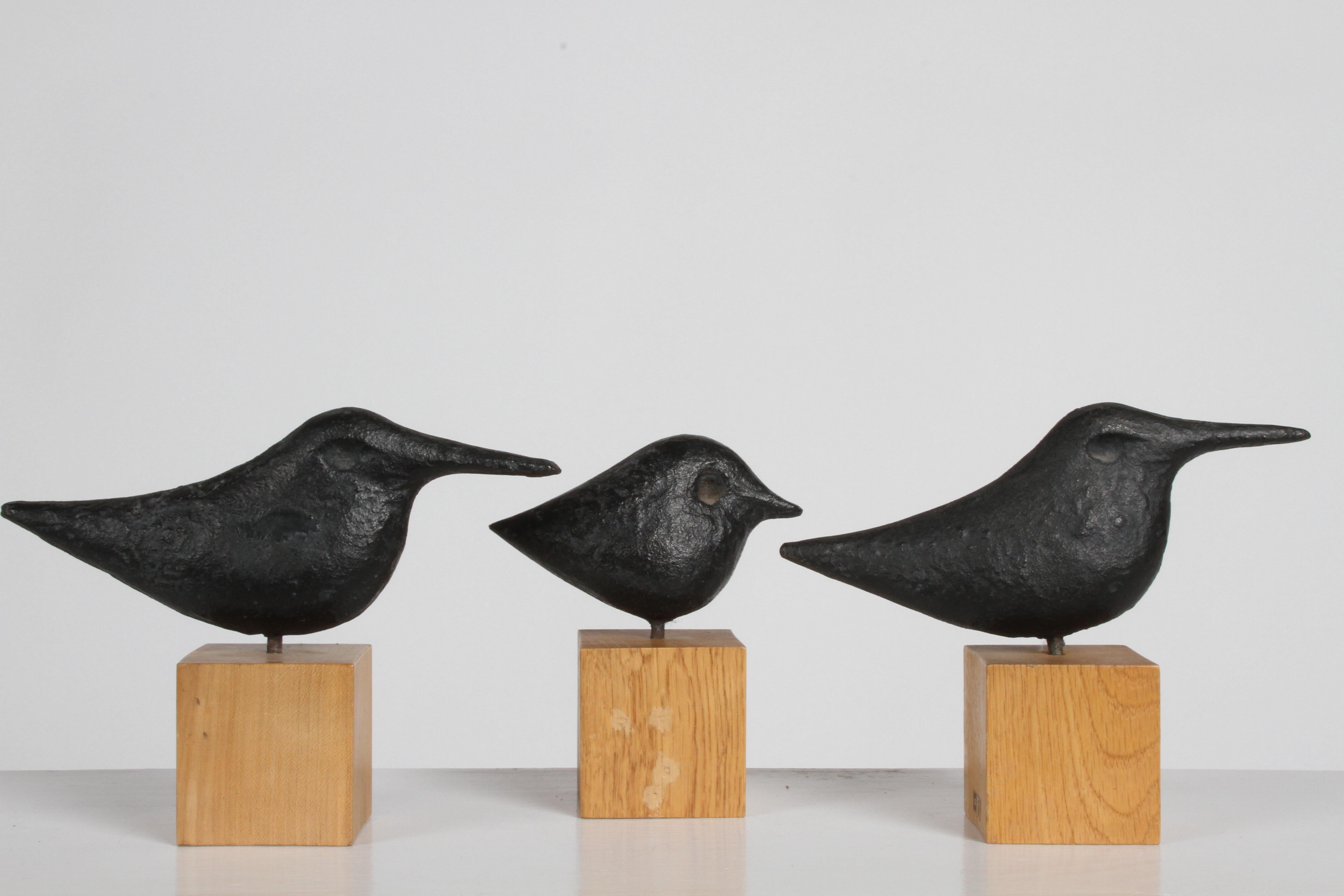 Set of three cast iron birds on wood cubes designed by Nobuho Miya (b. 1952). Miya a master forger of traditional cast iron, these cast iron birds reveal a Scandinavian influence that came from when Miya lived in Finland. 

Each is hand cast in