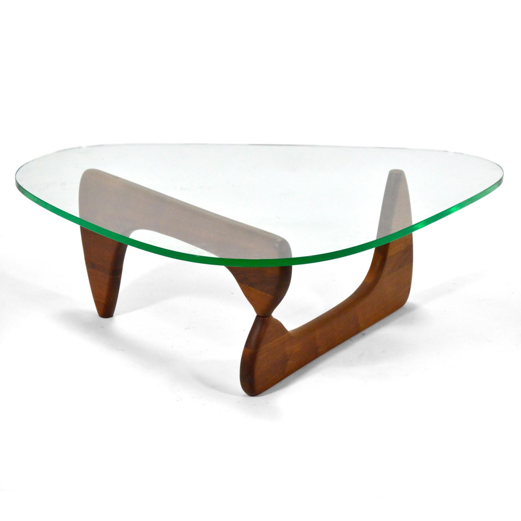 An exceptional early example of Noguchi's iconic functional sculpture, this table comes from the estate of a former Herman Miller executive. With a base of rich, oiled walnut and a glass top with the distinctive pale green edge, this very fine table