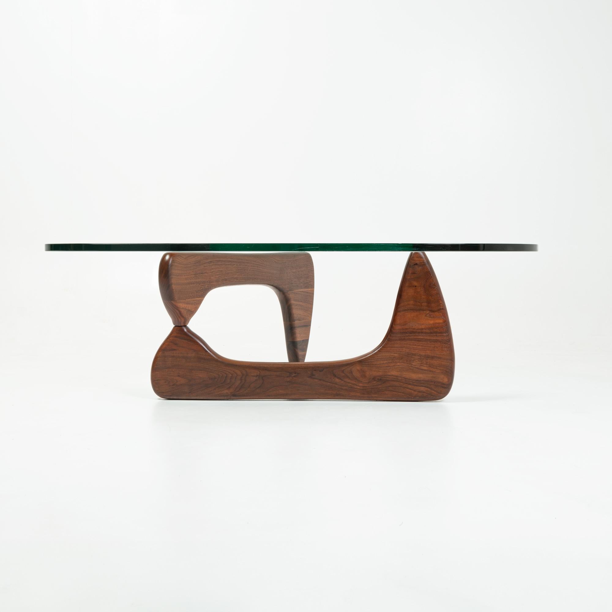 An early Noguchi IN50 coffee table with the original glass, originally purchased by first owner in 1970s. Walnut base with straight aluminum pin ( later pins has locking fins). Scratches on the glass, no chips.

Walnut base has been restored with