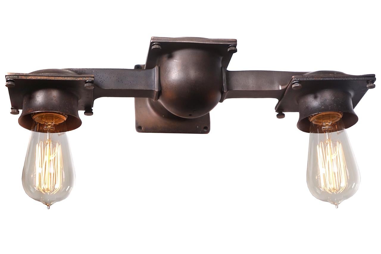 This is an identical pair of authentic early 20th century cast bronze double New York City subway station wall sconces. They were designed and fabricated specifically for the subway by the Russell & Stoll Company of New York City, NY. Several