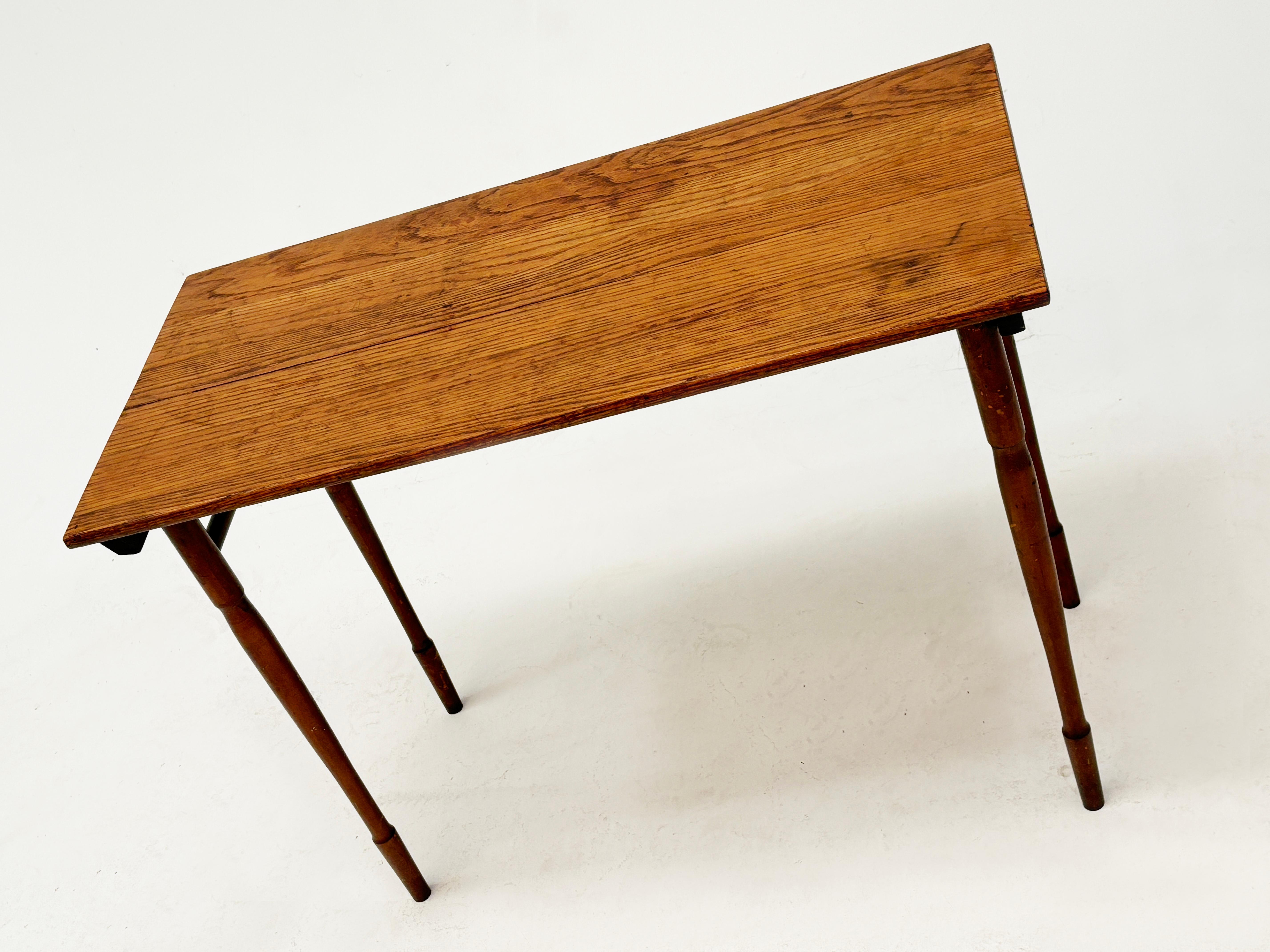There's something very unique about this early 1900's cutting/work table. Maybe it's the simplistically slim design. Or the unusual details seen in the thin brass rods that work smartly together to expand and contract the legs, revealing a bit of an