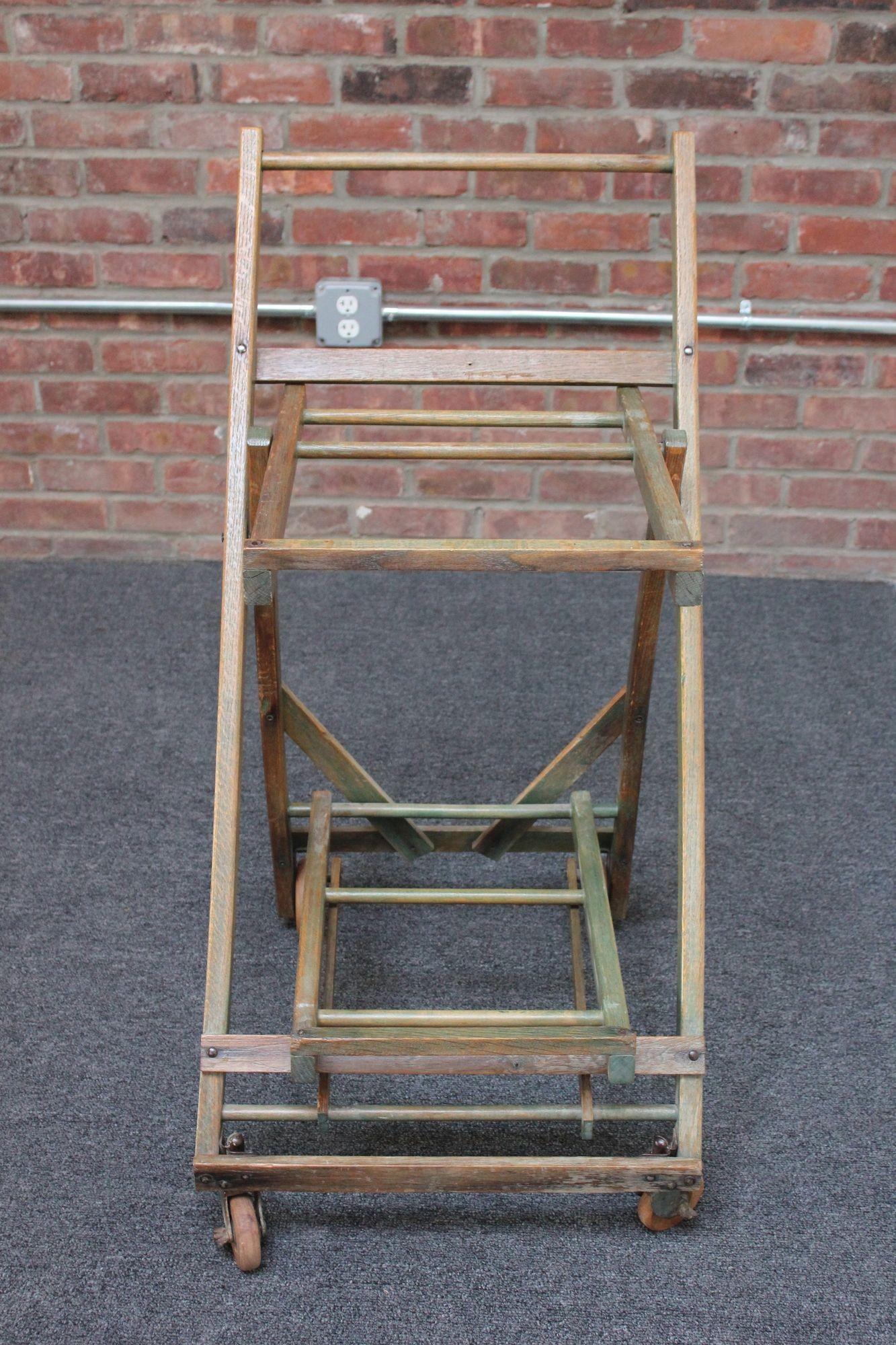 Charming oak collapsible shopping cart on caster wheels (ca. late 1930s/early 1940s, USA).
This early version, inspired by a folding chair, was developed by Sylvan Goldman in 1936 as a solution to the cumbersome shopping basket. It not only took up