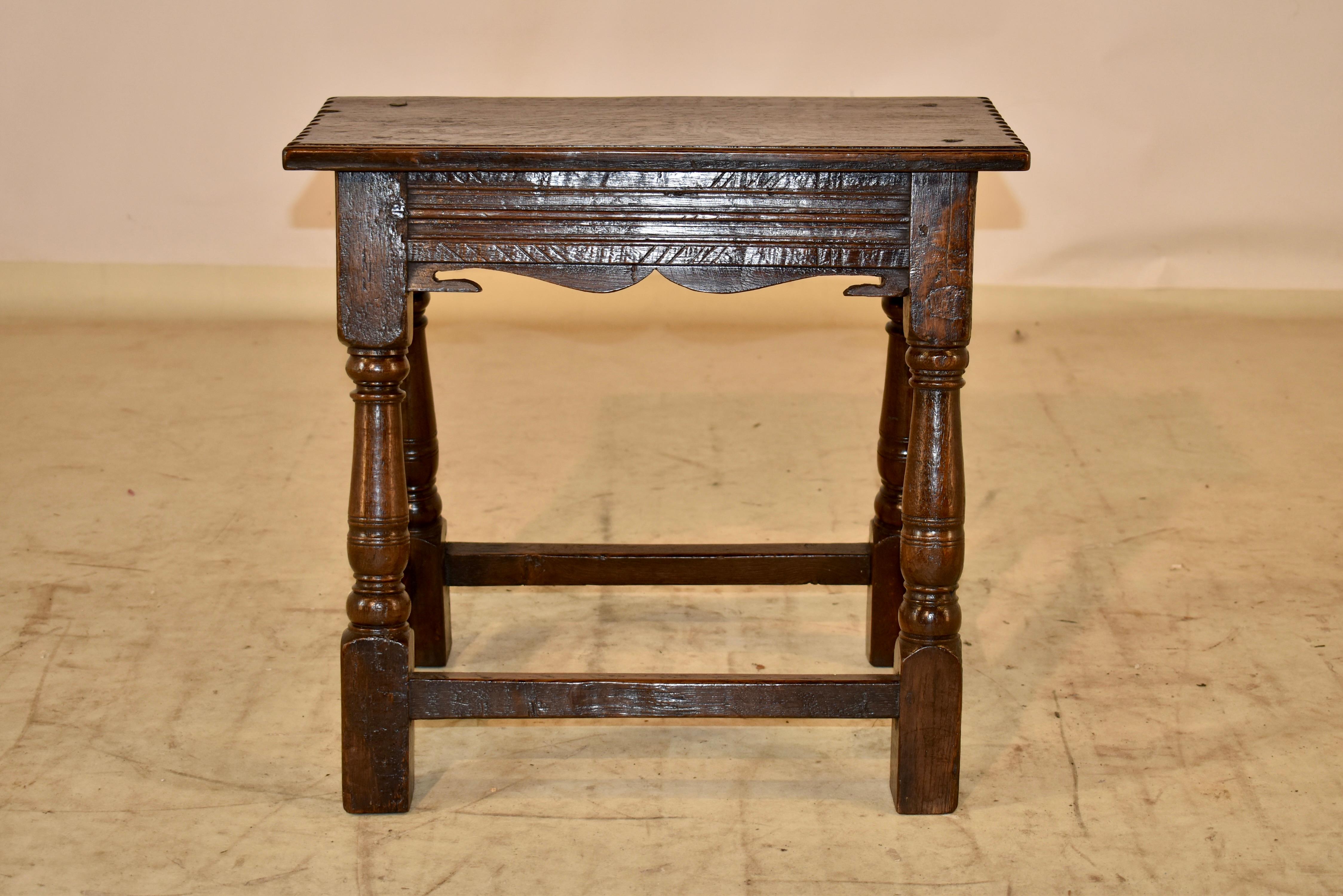 circa 1690-1720 William and Mary period English joint stool made from oak. The top has routing decoration on the front and back sides, and has pie crust decoration on the sides. The construction is pegged. The top follows down to a lovely hand