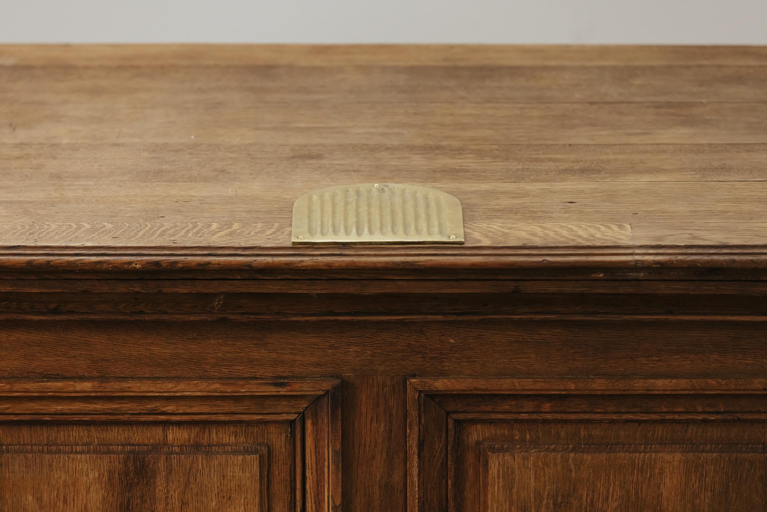 Early Oak Shop Counter From France, Circa 1940.  Solid oak construction with original brass countertop detail.  Nice wear and patina.