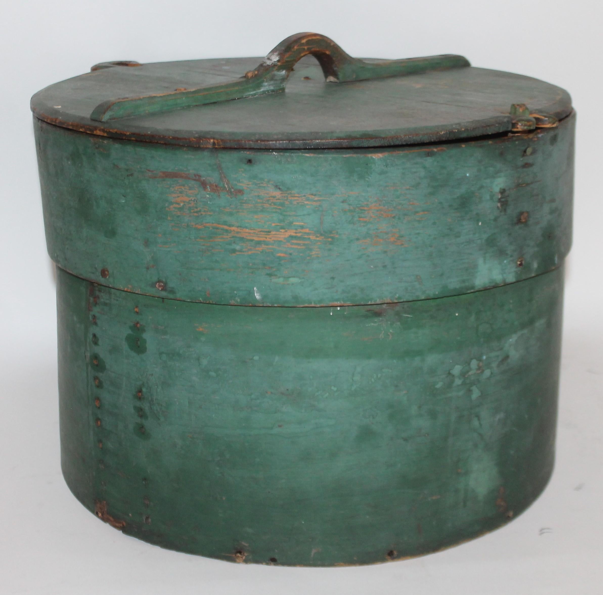 This large size pantry box or meal box is in original fantastic green paint. It is in the form of a large band box and hand carved handle and early wood peg construction.