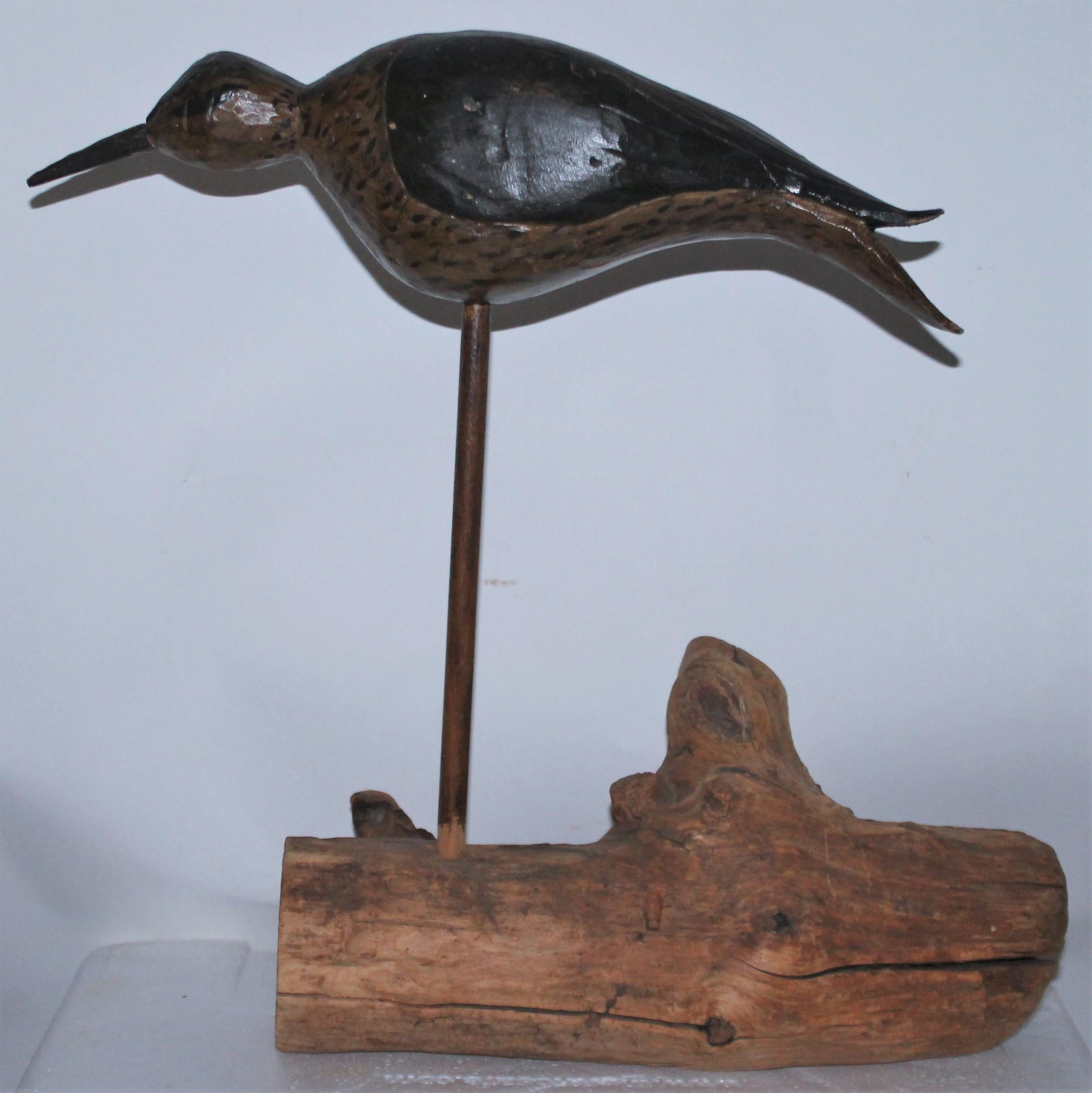 This fine early 20th century original painted and carved shore bird on wood log base. The bird has a coat of wax or something like varnished.