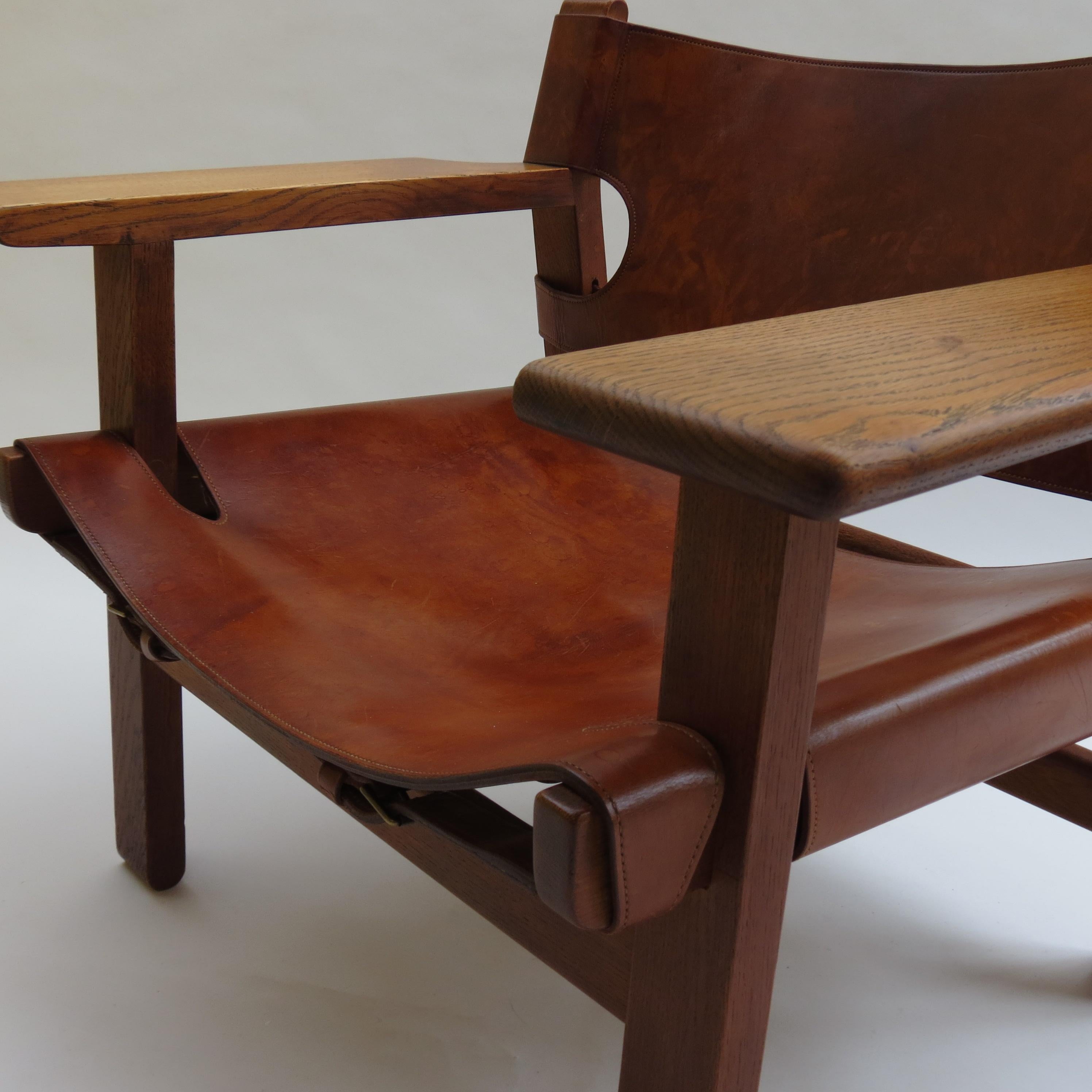 This is an early original Spanish chair by Borge Mogensen, Denmark. This is an early example with stitching detail to the leather back panel on the outer edge.

The chair is wonderfully patinated, the oak frame is a wonderful rich color and the