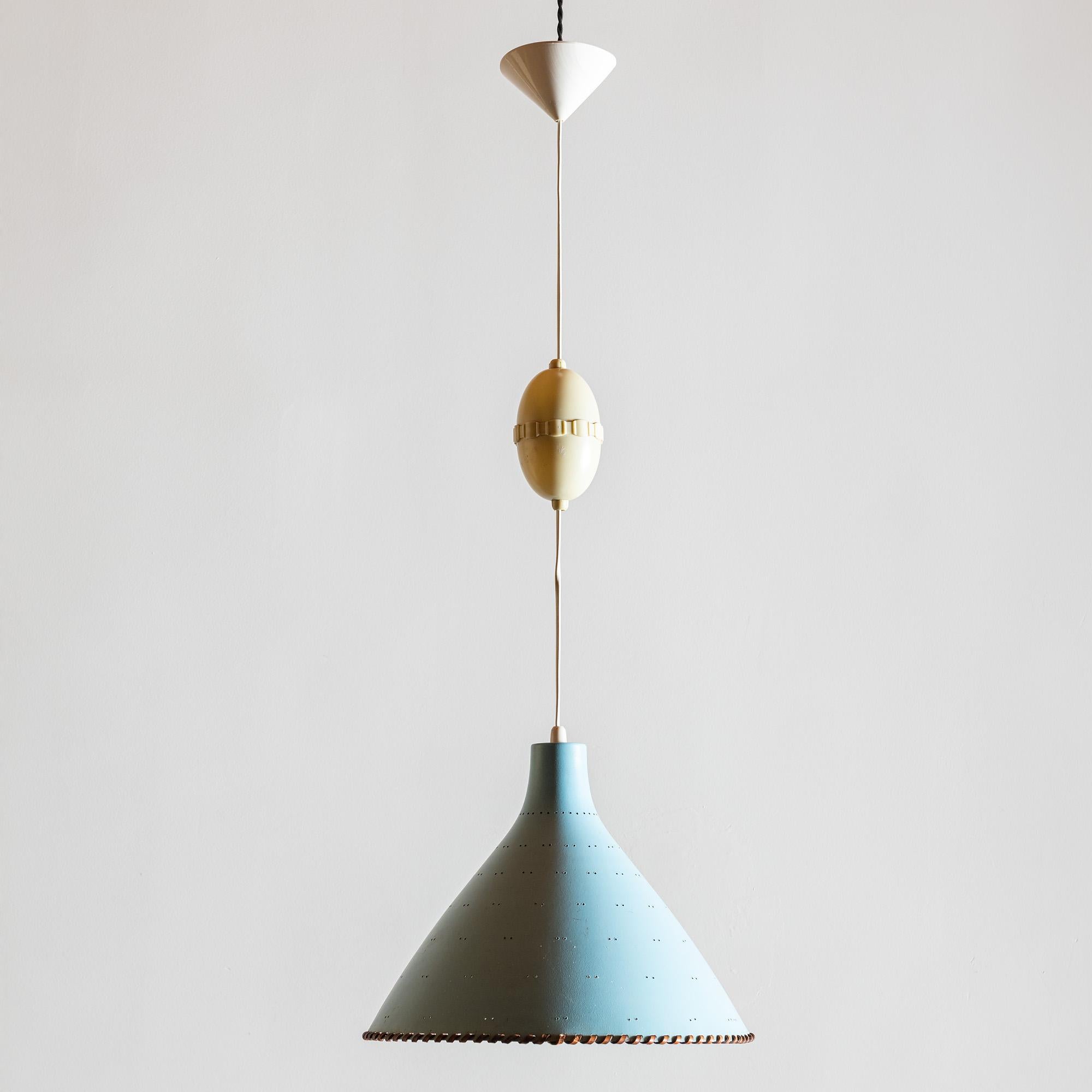 An early gorgeous pendant by Paavo Tynell for Taito Oy in blue lacquered metal with brass accents and leather whipstitching. Shade has decorative perforations. There is a cord retractor currently on the drop cord which could be removed if desired.