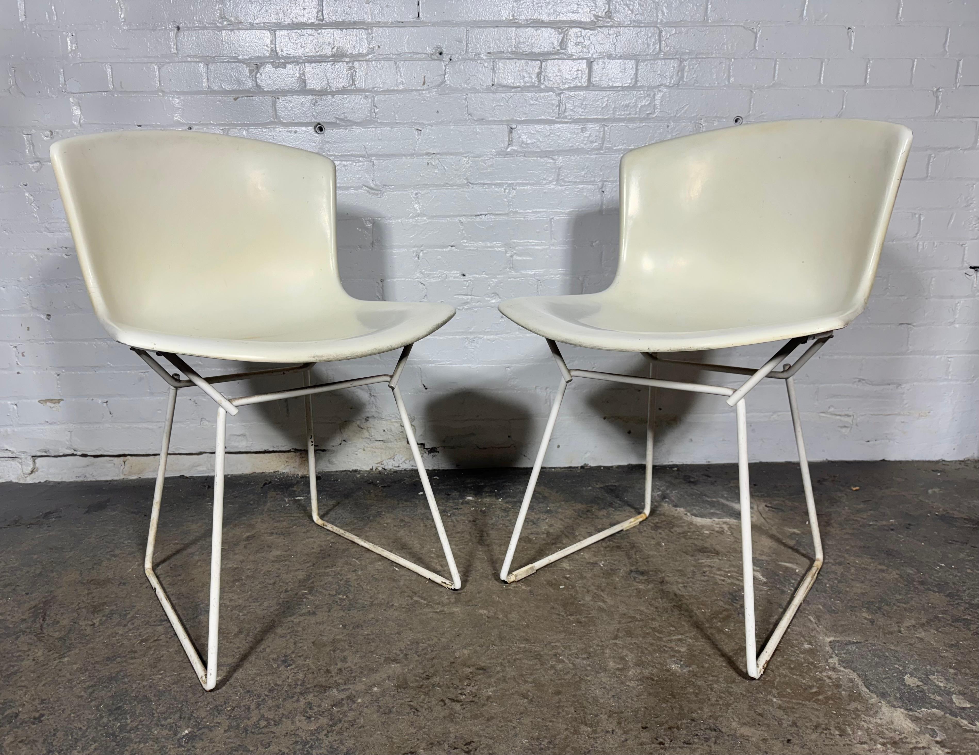 Coppia di sedie a guscio in fibra di vetro stampata disegnate da Harry Bertoia e prodotte da Knoll. Debuttato originariamente nel 1960, questo set molto precoce è del 1966. Colore bianco classico modernista, lievi segni di usura sui bordi.