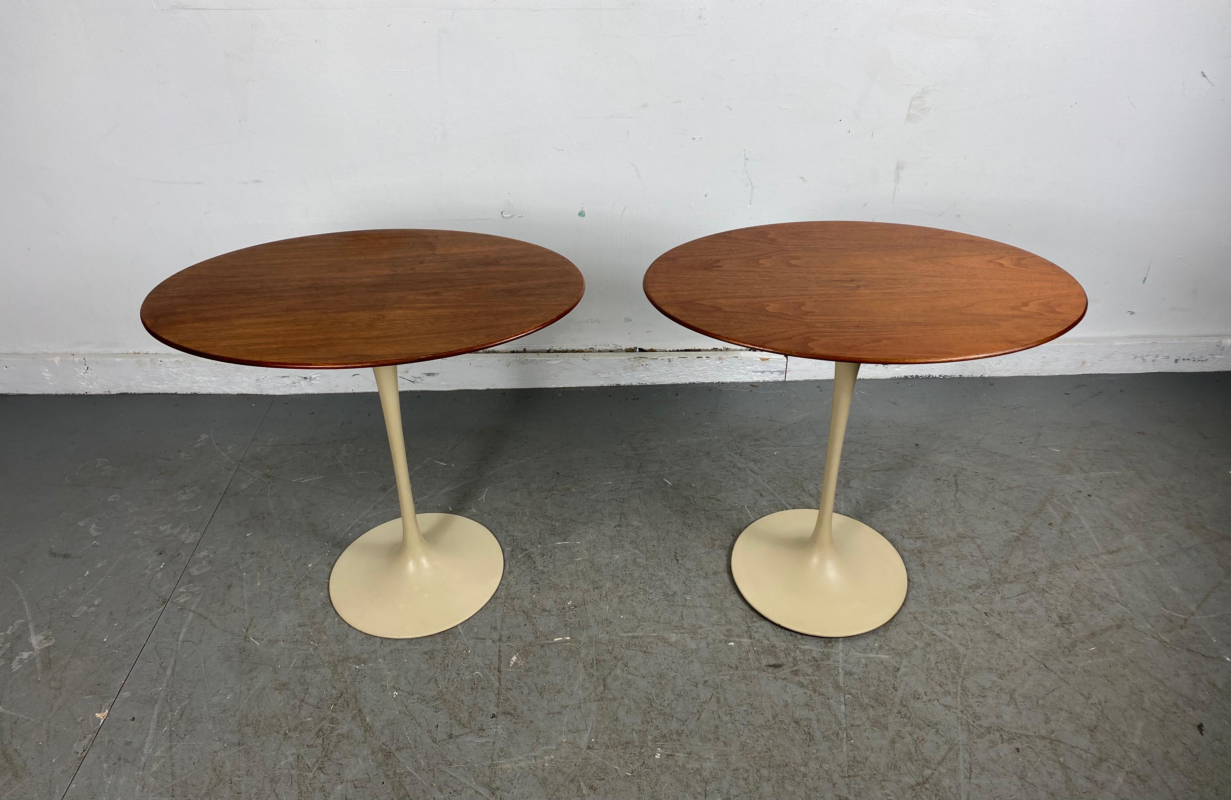 Early pair of Knoll tulip oval side tables by Eero Saarinen, circa 1970s. Walnut oval beveled tops, ivory white tulip pedestals. Nice original condition, retains original Knoll label.