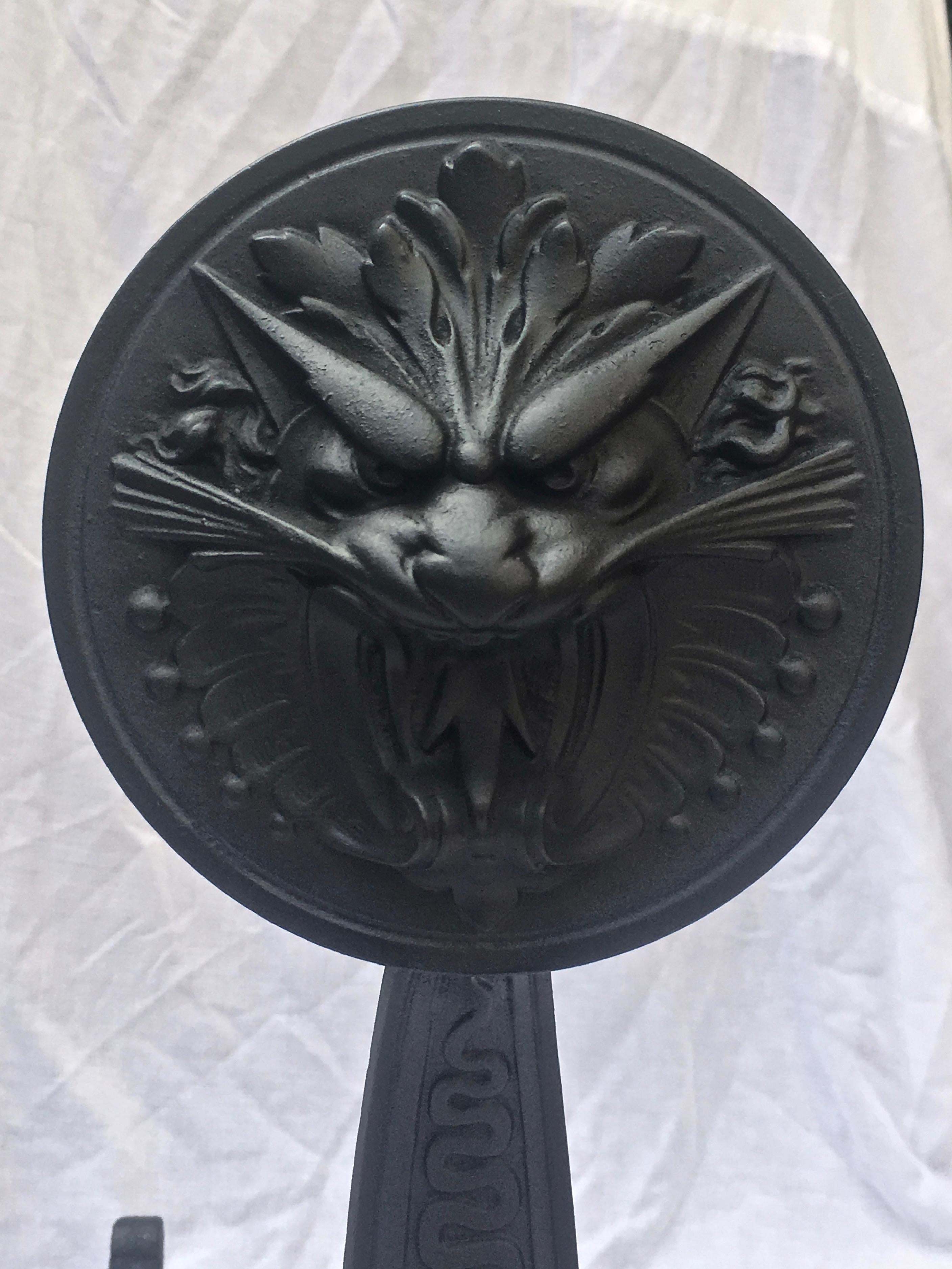 Pair of Andirons are made of cast wrought iron depicting the face of a roaring gargoyle with a, serpentine, detailed body. The stamp of B &H is on the back side along with the original Patin date of 1886.