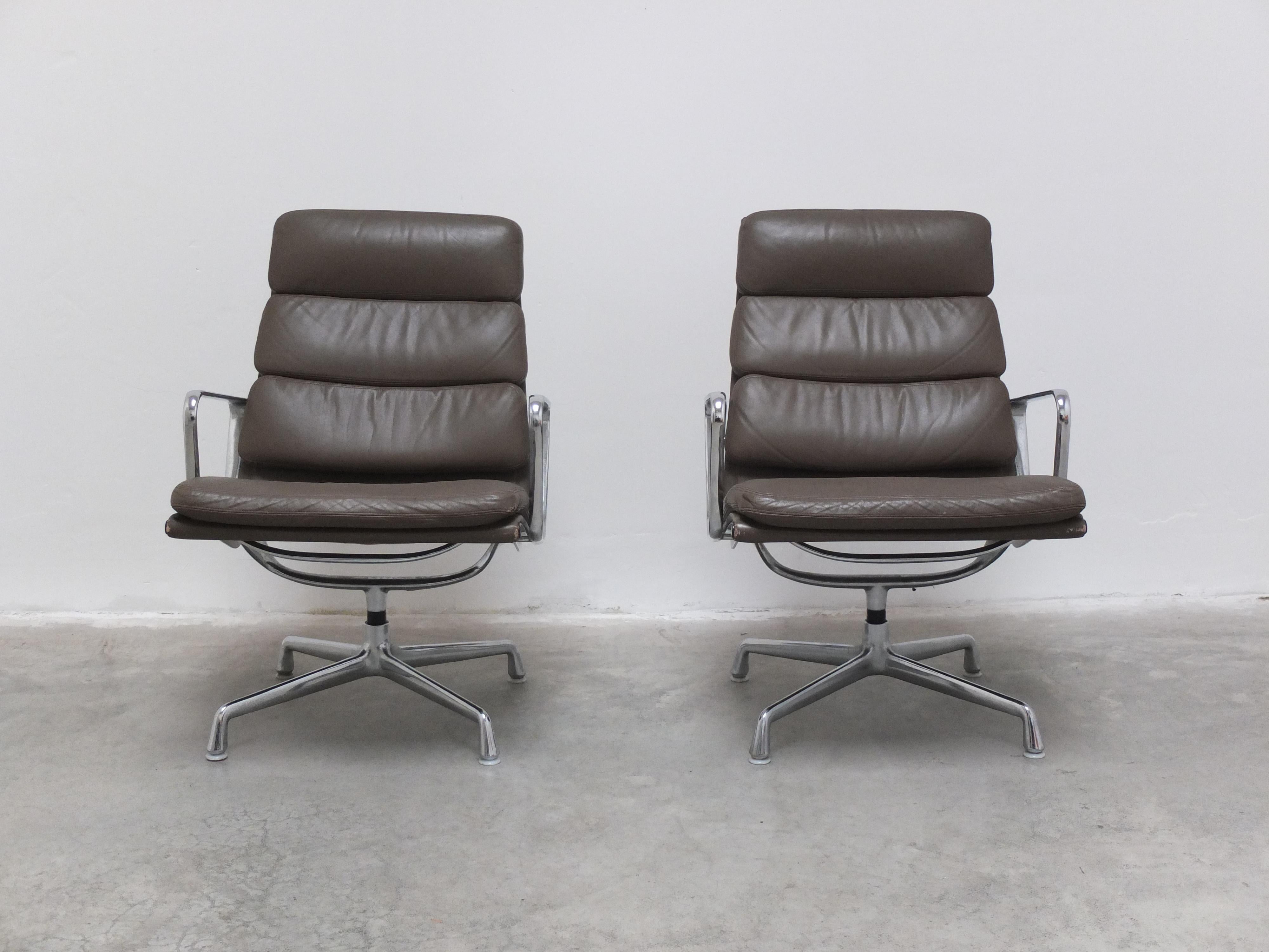 An early pair of model ‘EA216’ swivel lounge chairs designed by Charles & Ray Eames in 1969. This is a high back version with rare sand-colored brown Soft Pad leather for maximum comfort. It has an aluminum frame and armrests and stands on a 4-feet