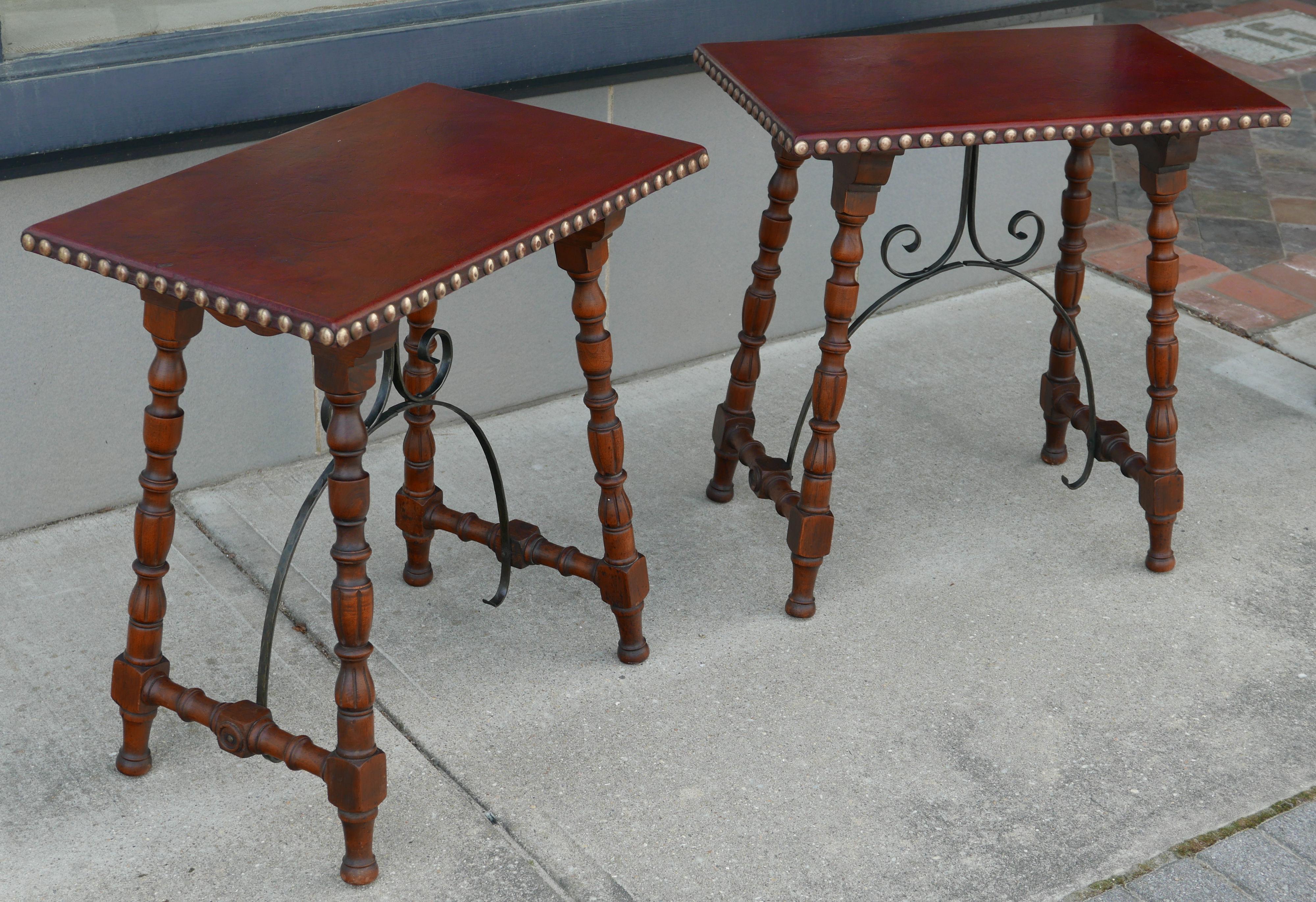 Wonderful leather top tables with large nailhead trim and Spanish colonial base in solid oiled walnut with forged iron brackets for the trestle-like base. Rare to see one of these tables, which would fit in wonderfully in a Southwest or southern