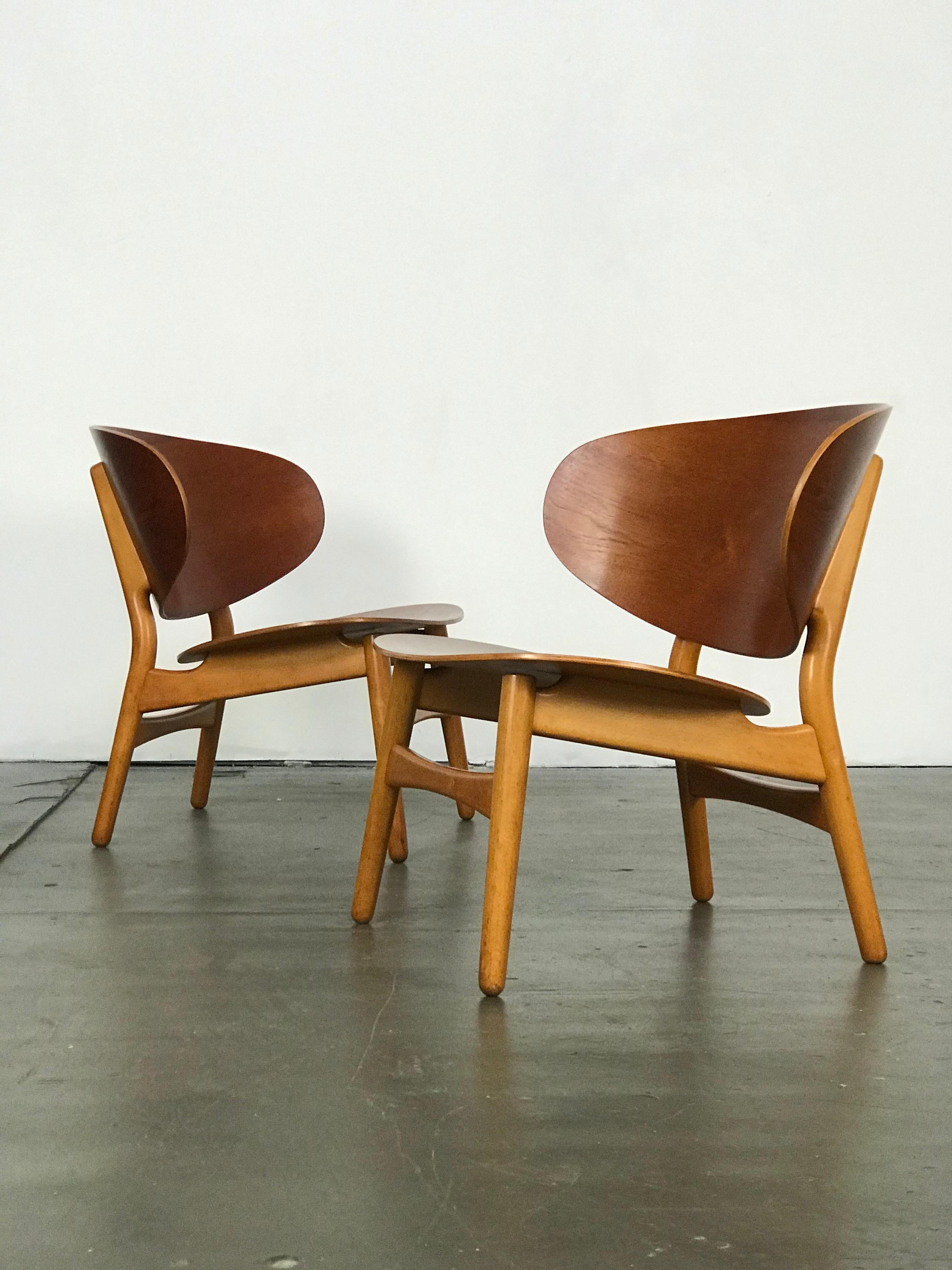 Early pair of Hans Wegner Shell lounge chairs. Designed in 1948. These have been recently restored, yet still show some age/wear. The chairs are made of beautiful contrasting wood types; teak and beech. FH stamps under each chair. Early photos of