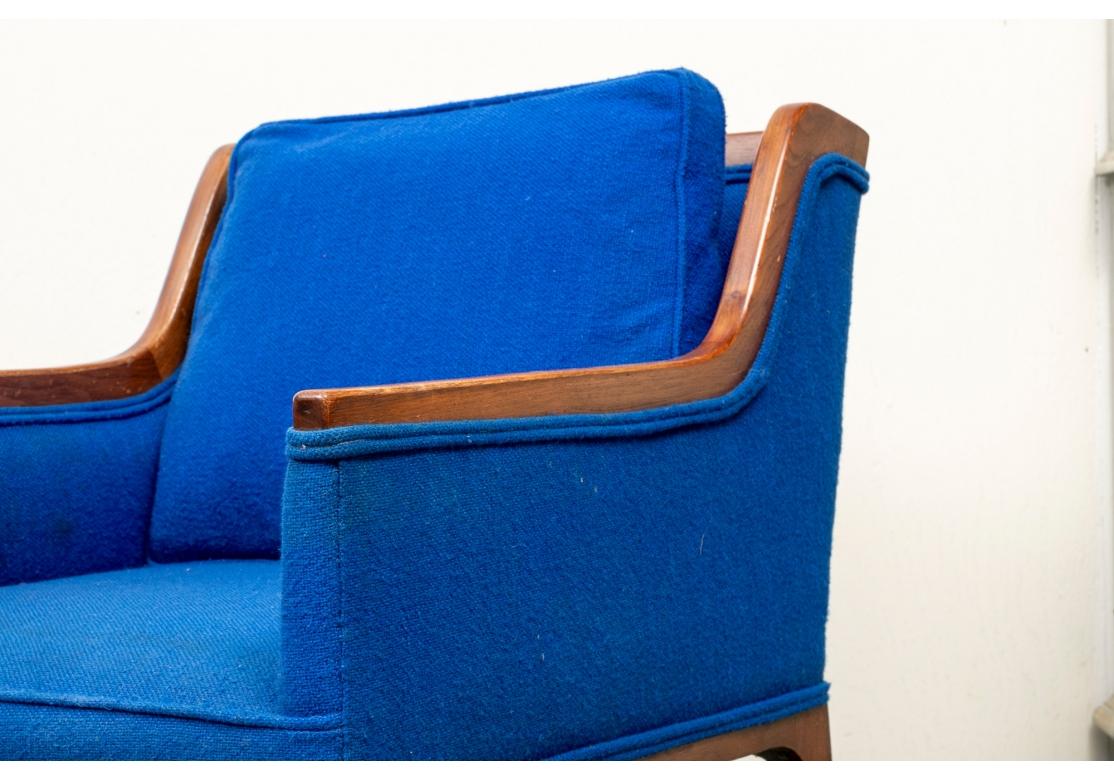 A more diminutive pair of Club Chairs dated to the 1950’s and attributed to Kipp Stewart. Having nicely time-softened mahogany frames with sloping arm with tapering legs and upholstered in a Royal Blue fabric with fixed seat and loose back cushion. 