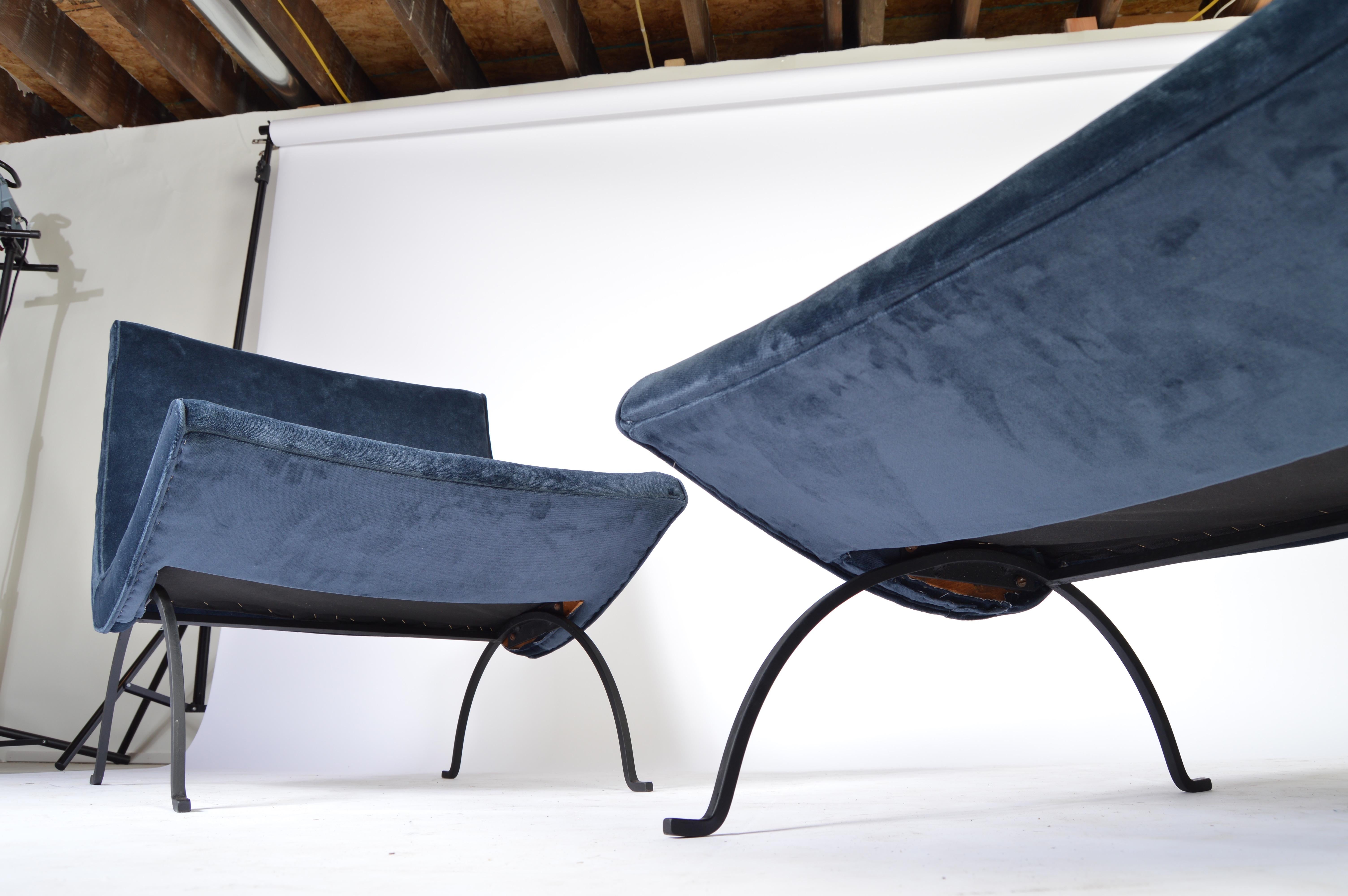 A 1950s pair of scoop lounge chairs designed by Milo Baughman having black, solid iron frames and fresh velvet upholstery with new cushioning.