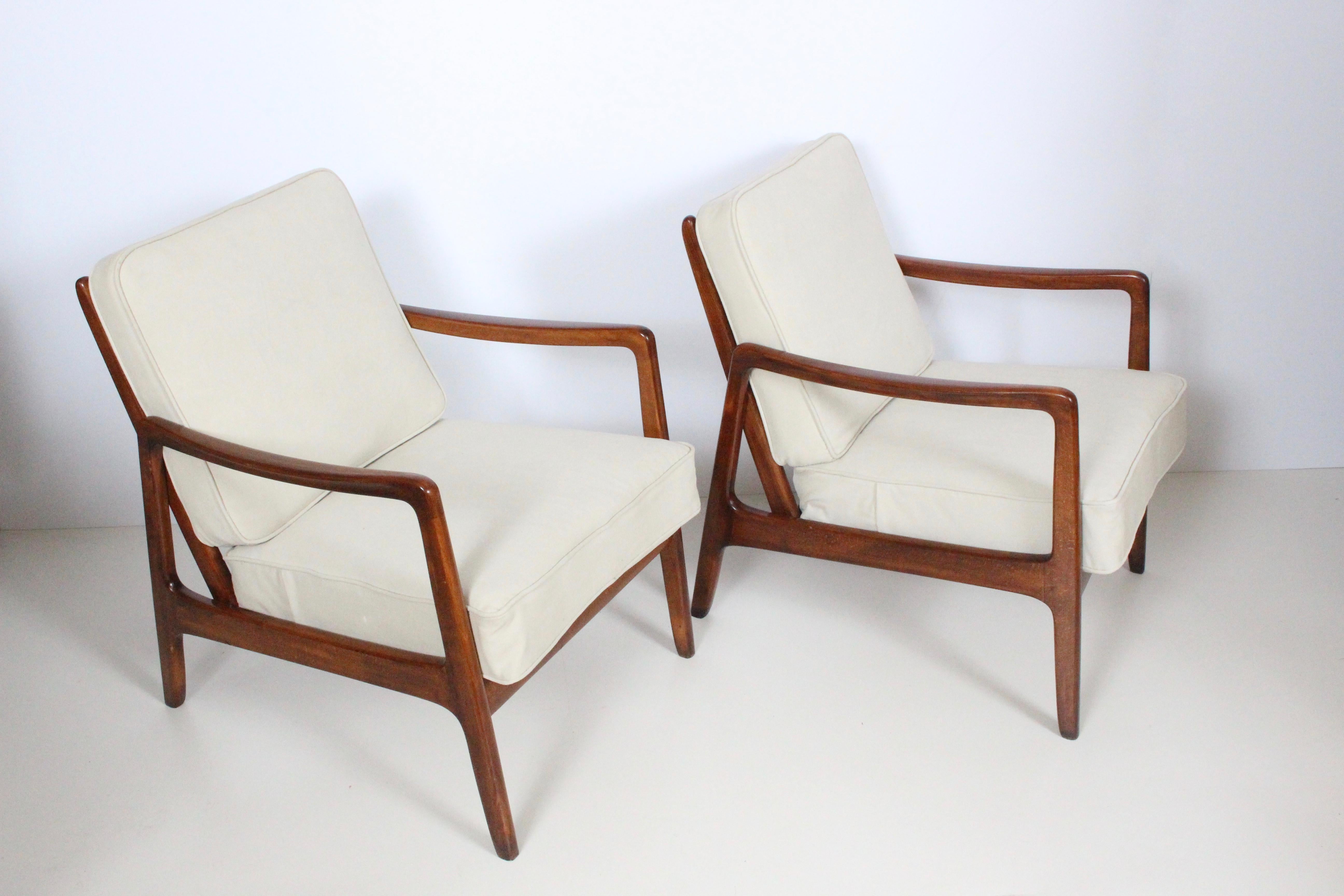 Danish modern pair of solid Cuban mahogany lounge armchairs by Ole Wanscher designed for France and Daverkosen distributed by John Stuart. Featuring solid and sturdy mahogany angled ladder back style framework for ultimate comfort, with newly
