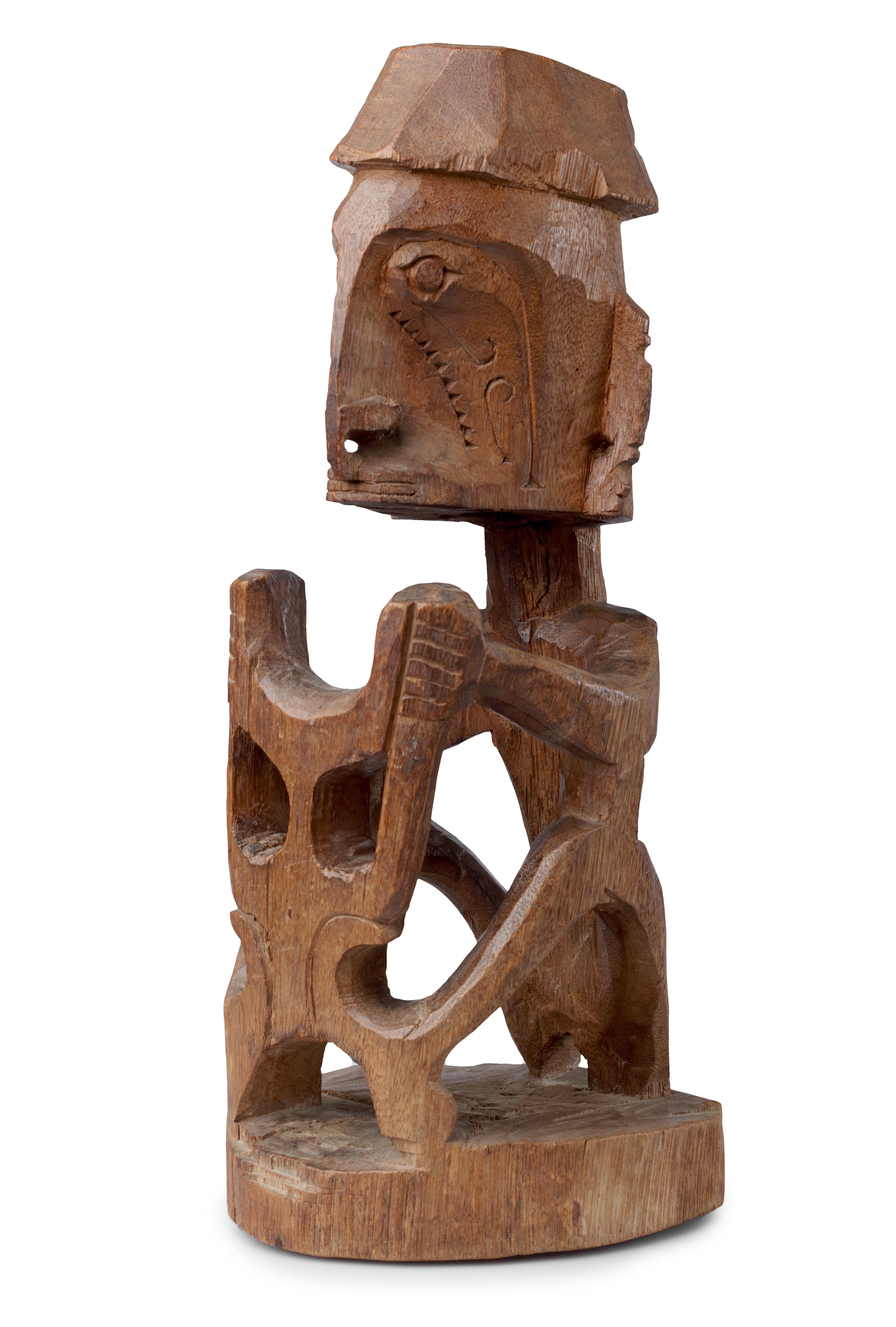 A Papua wood figure of a Korwar

North West Irian Jaya, Vogelkop area, coastal Geelvink Bay, present-day Cenderawasih Bay, early 20th century

The seated Korwar is holding an openwork “shield” in front of him, with a dark brown soft gloss