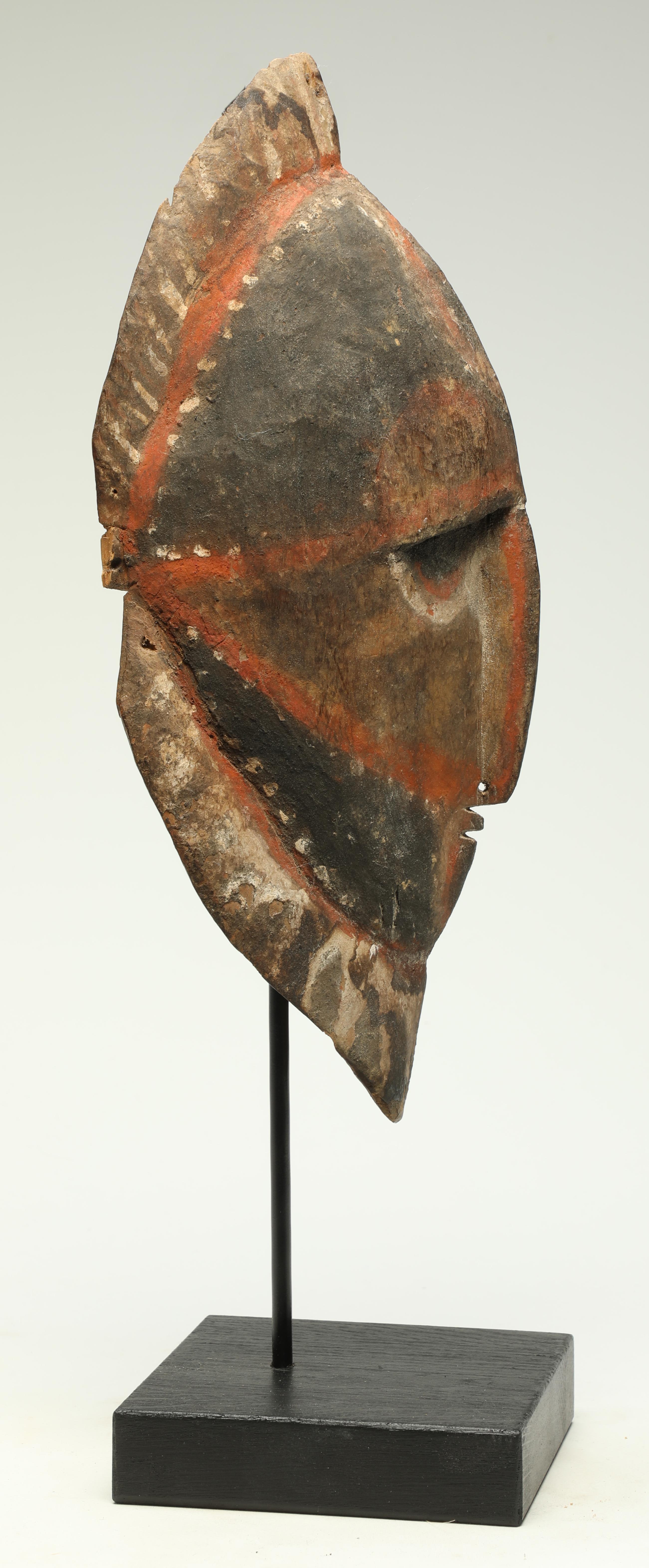 Early Papua New Guinea painted Maprik carved hard wood mask. Mid-20th century, with wonderful curved expressive asymmetrical face. Long nose with pierced septum. Faded polychrome pigments with yellow, white, black and red. 
Mask is 13 inches high,
