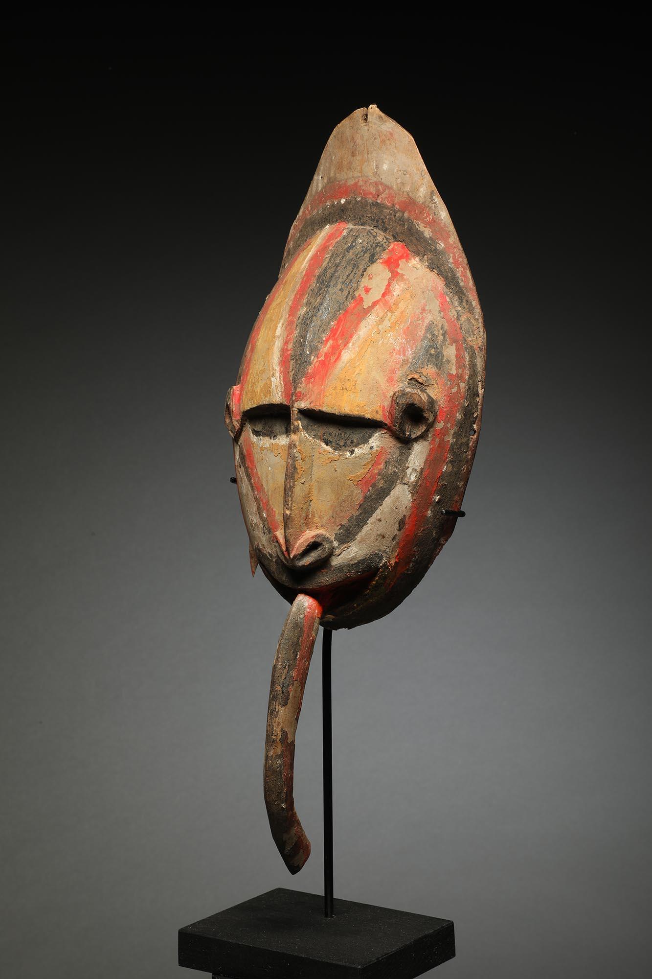 Early Papua New Guinea painted Maprik carved wood mask with long curved tongue. Mid-20th century, ex Michael Hamson, CA with label on back. Classic Maprik colors with faded polychrome pigments with yellow, white, black and red. 
Mask is 16 inches