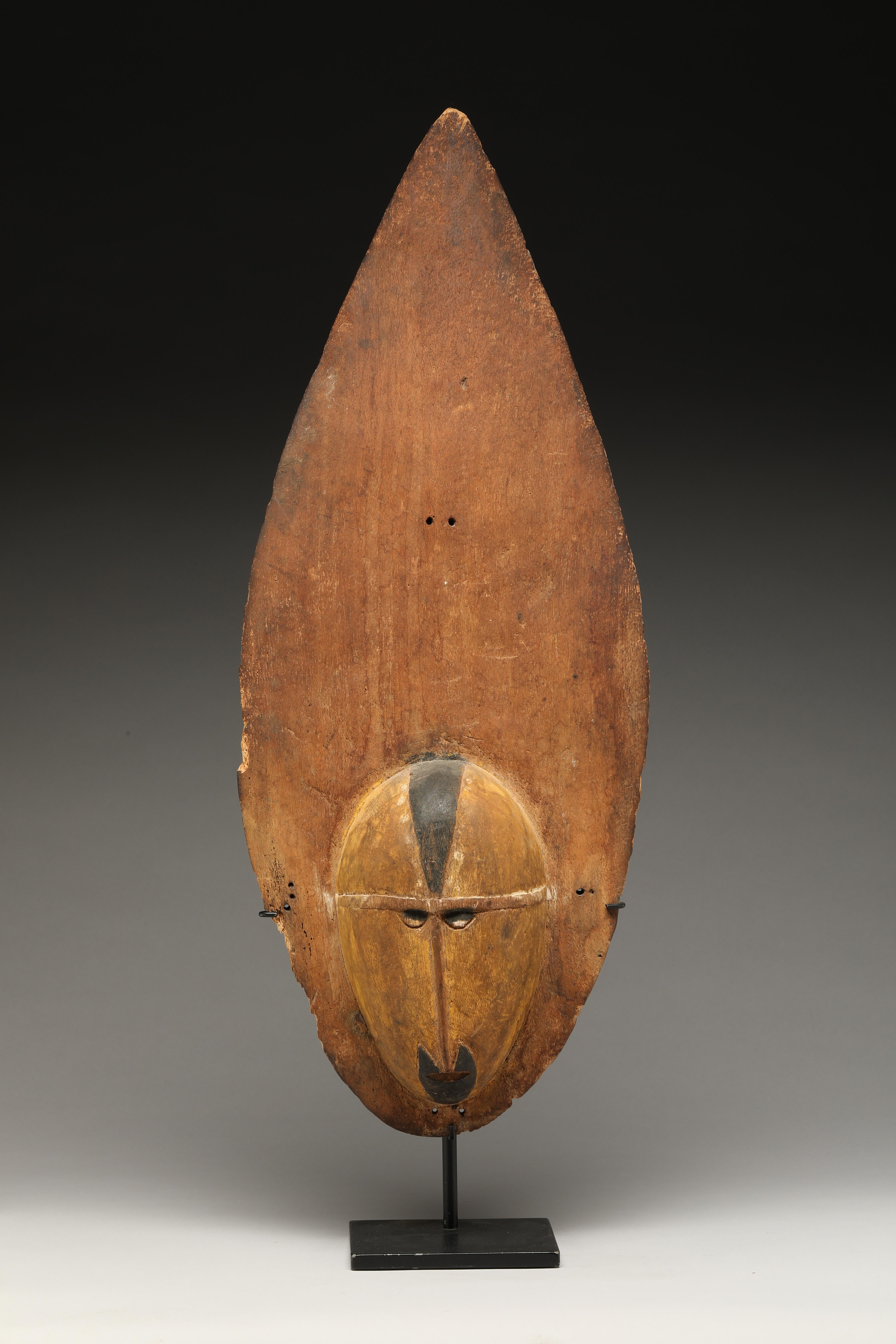 Early Papua New Guinea Sepik light wood yam mask. Elegant flame shaped form, old, oxidized wood with black accents, traces of yellow and white pigments. Small holes originally for attachment. Refined well carved face. Old chips and wear around